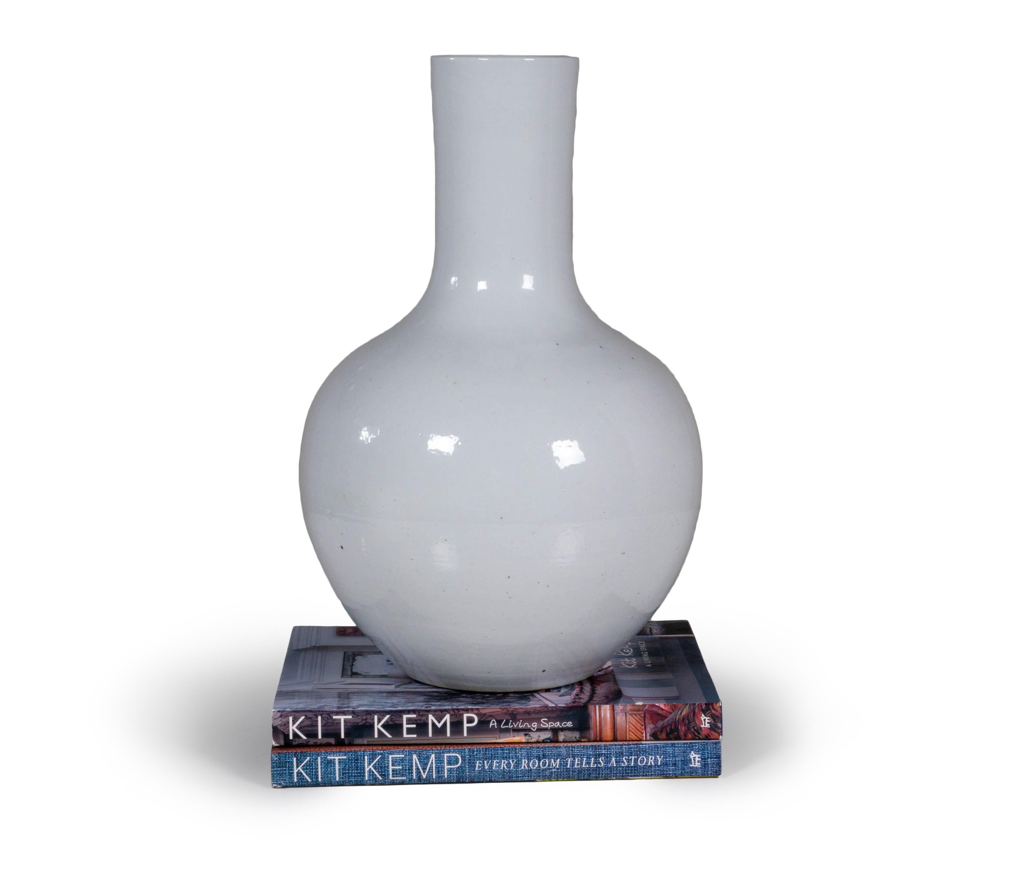 A modern take on the classic vase, this white ceramic version is a versatile piece for any decor. Designed with a wide base, this design makes it perfect for pairing with larger arrangements. This elegant white ceramic vase is finished with a glow