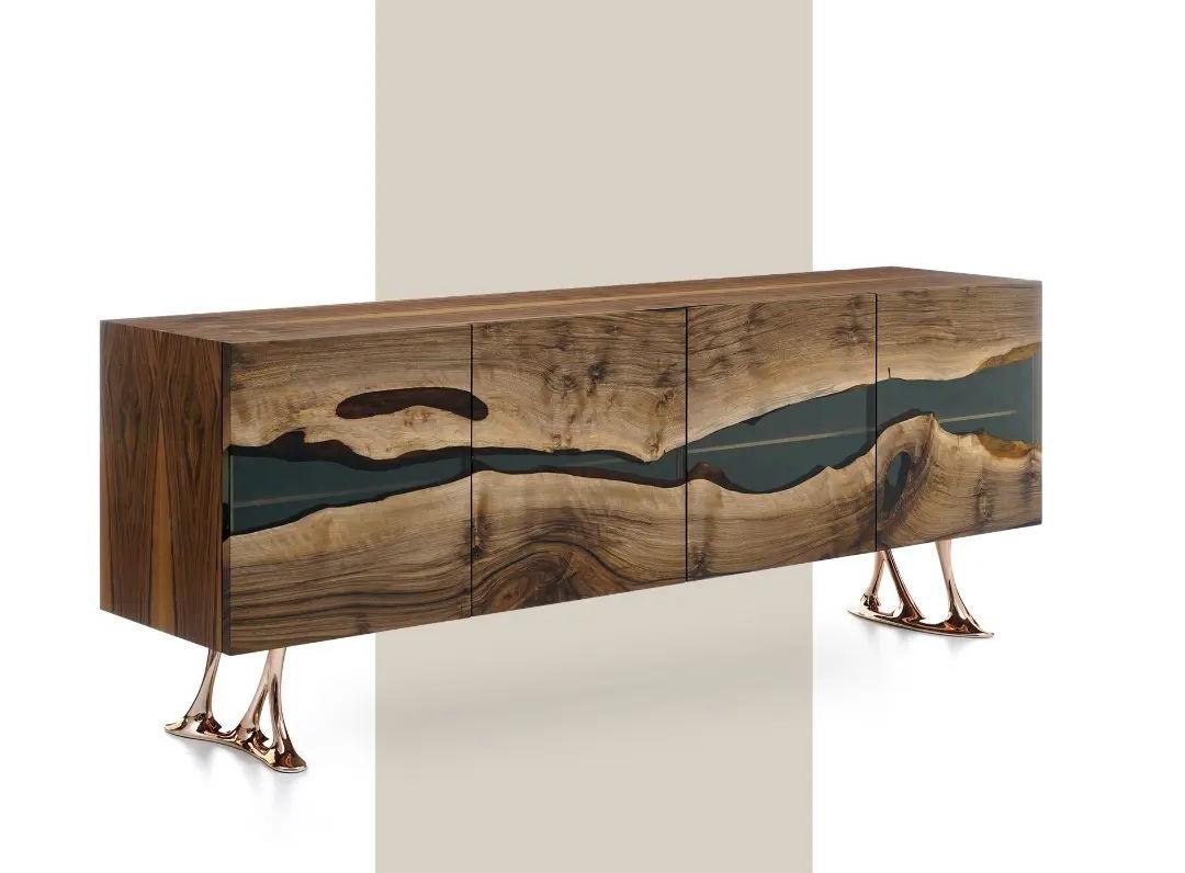 The Medma Credenza is a stunning piece of furniture that will undoubtedly elevate the ambiance of any space. This masterfully crafted credenza is made from high-quality walnut wood, which is known for its durability and natural warmth. The timeless