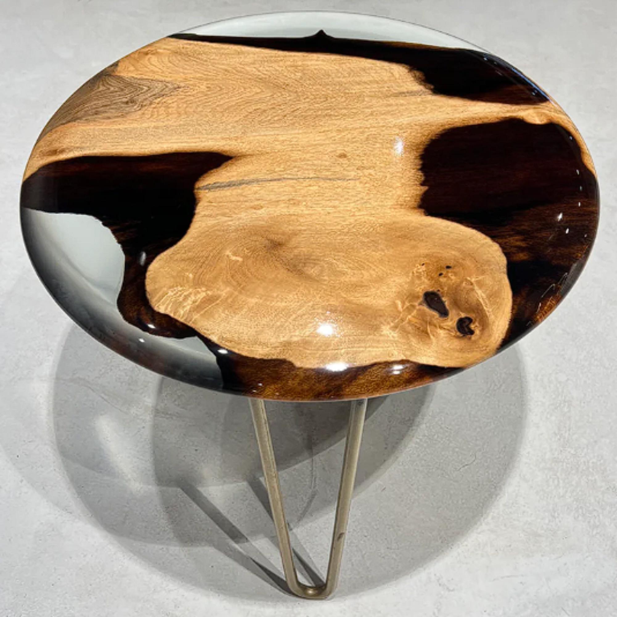 Voici la table d'appoint ronde Medma, un meuble époustouflant qui rehaussera n'importe quelle pièce de votre maison. Fabriquée avec une combinaison de bois de noyer de haute qualité et de résine cristalline, cette table d'appoint est à la fois