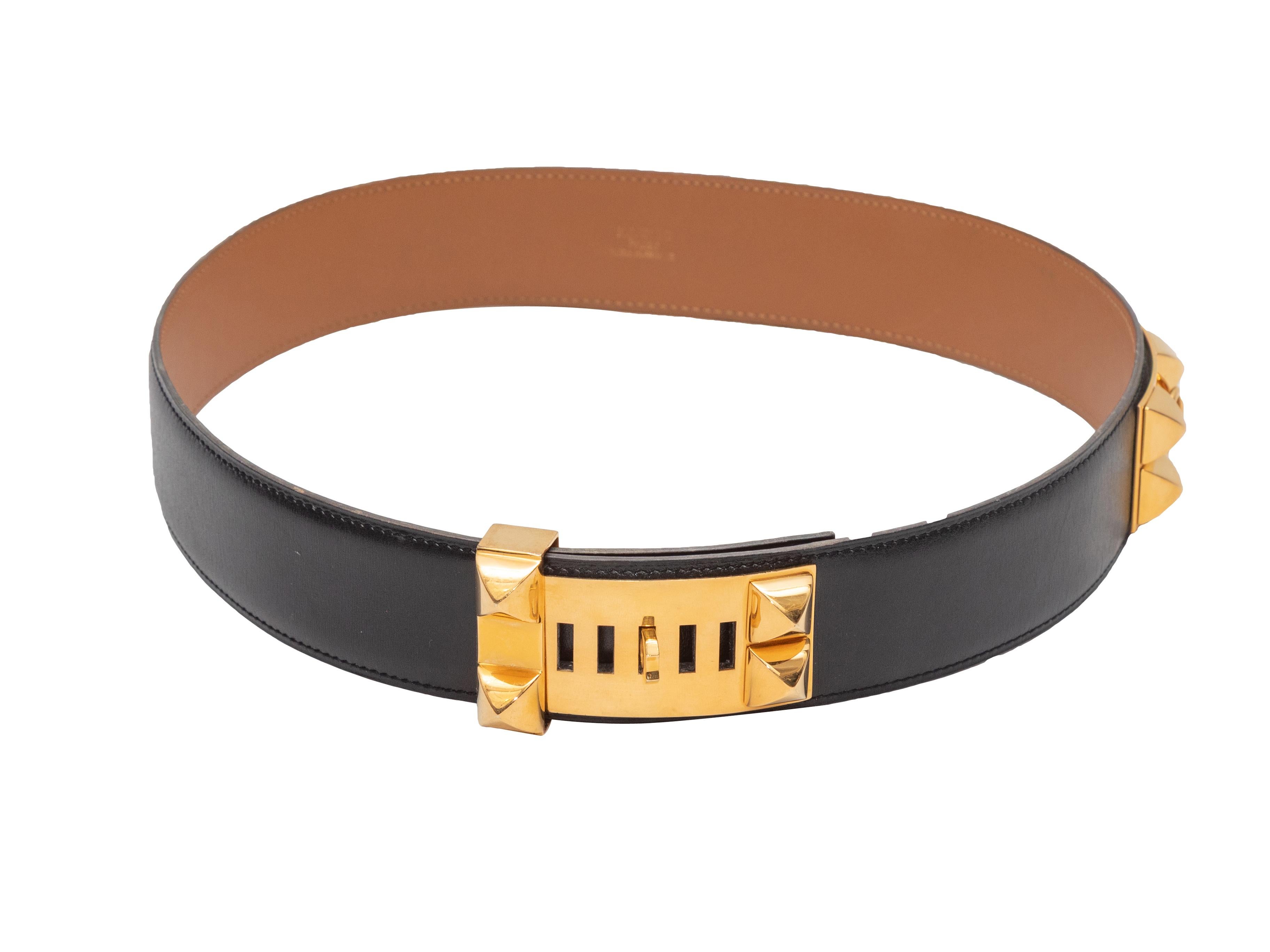 Medor black studded belt by Hermes. Circa 1994. Gold-tone hardware. Front buckle closure. 1.5