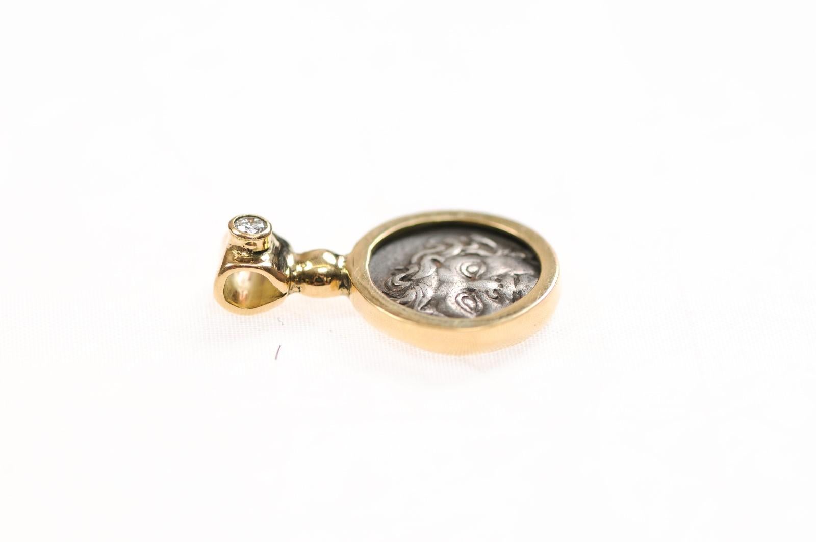 Un ciondolo in argento con testa di Medusa e un'ancora decorata con oro 18 carati e un diamante. Questa dracma è stata coniata ad Apollonia Pontika, in Tracia, nel IV secolo a.C. circa. Al dritto, il volto di una gorgone o di una medusa, con