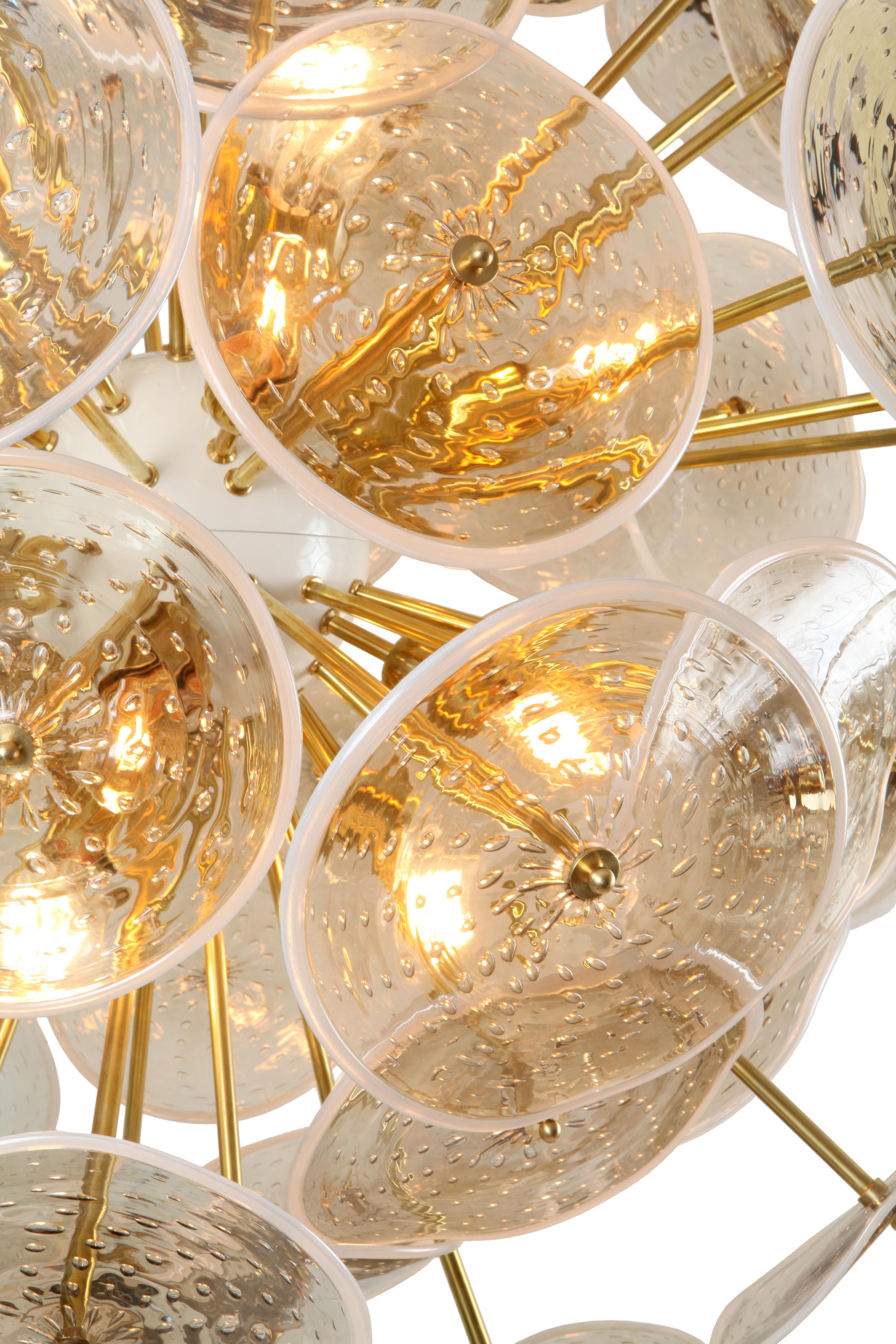 This Sputnik chandelier is made to order with a central white powder coated brass orb, natural brass rods at two lengths, a brass drop rod and white powder coated brass canopy. The glass discs are hand blown Murano glass with a 