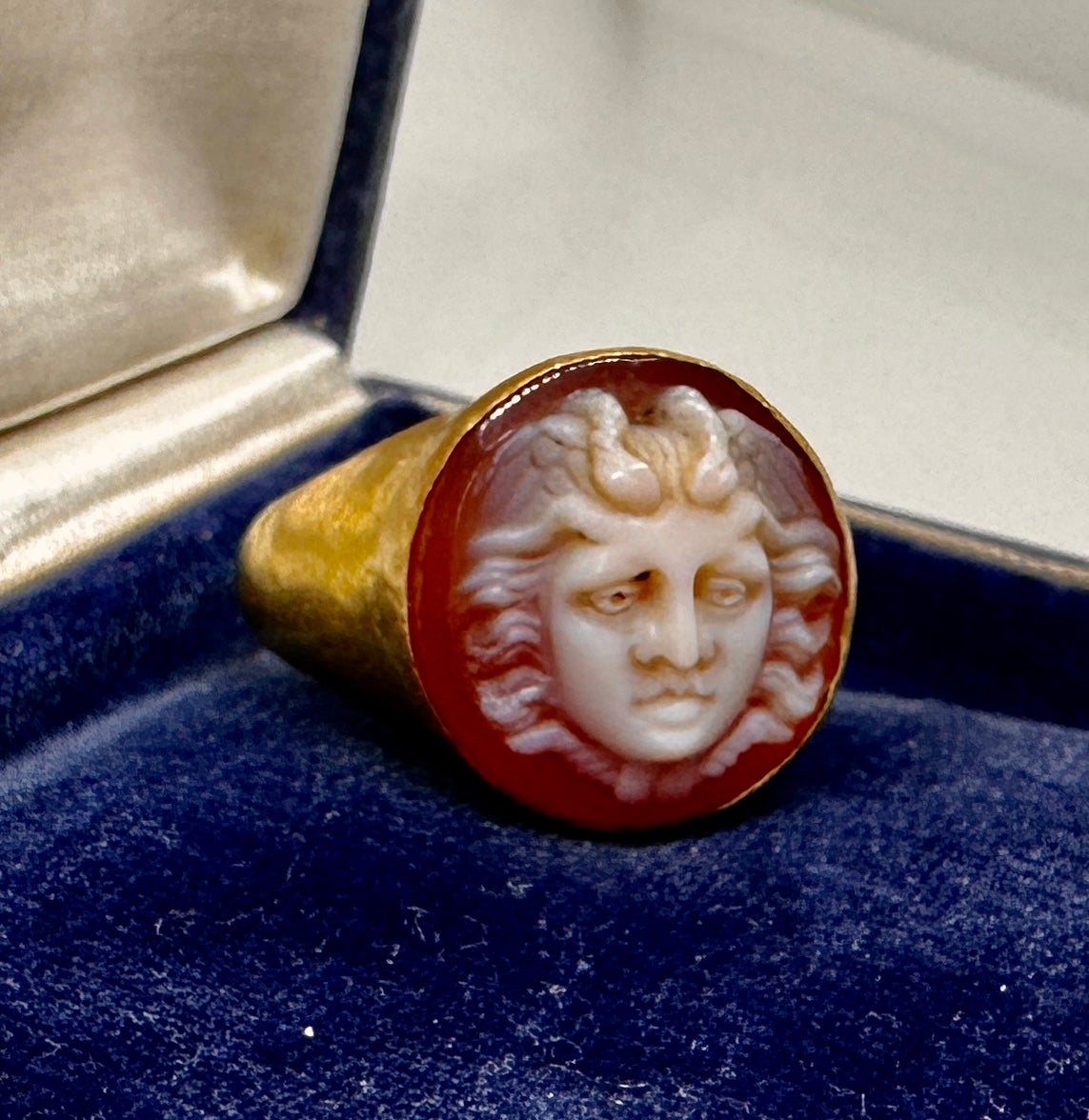 Indulge in a Museum Quality Medusa Snake Hard Stone Cameo Ring in 20 Karat Gold.  The Antique 19th Century Victorian Carved Hard Stone Cameo is a masterpiece of Cameo carving.  The ring depicts Medusa with a Crown of Snakes with two fabulous snakes