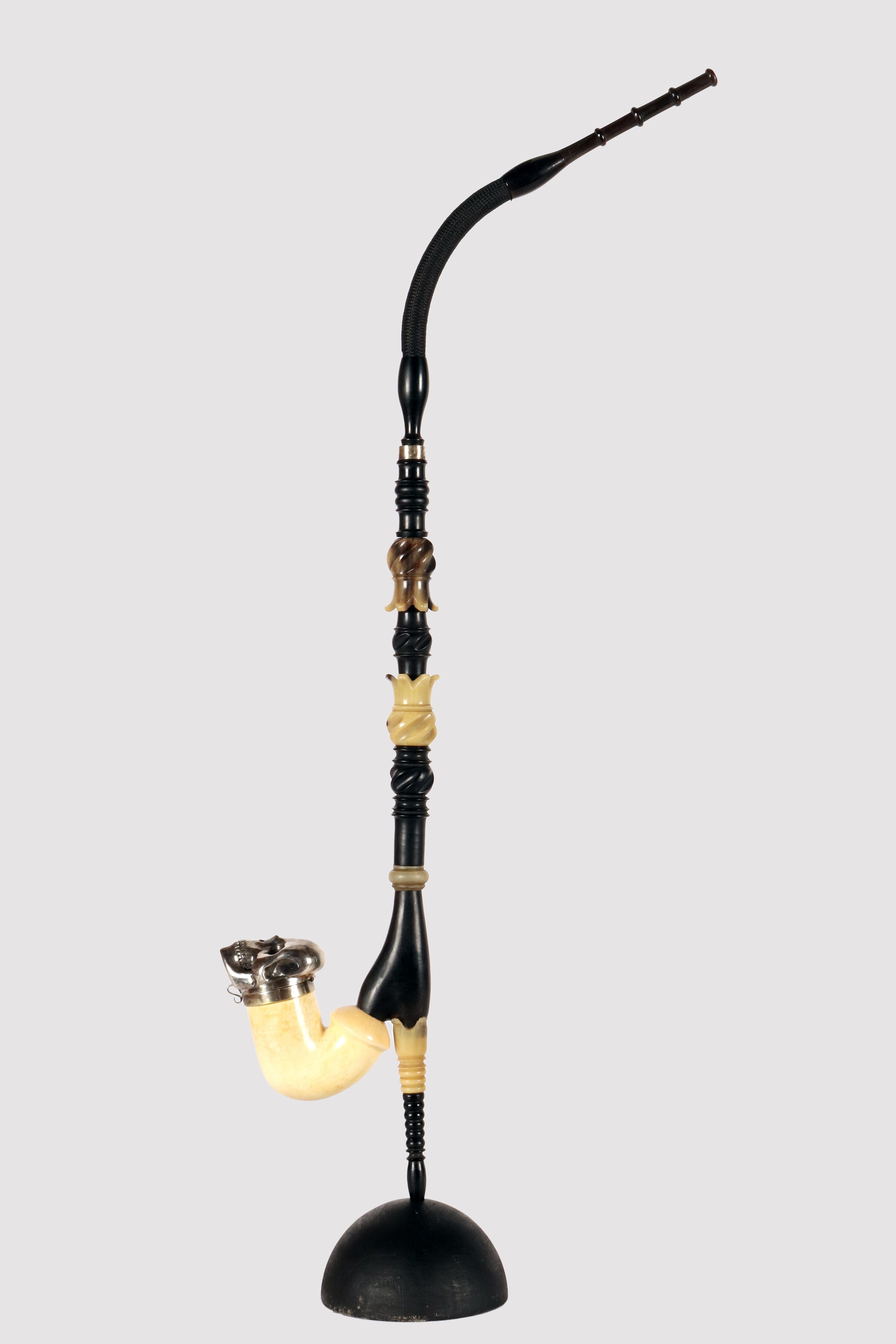 Rare and unusual pipe, depicting a Vanitas-Memento Mori in meerschaum. The long mouthpiece is carved and carved in light and dark ox horn. The alternating elements that compose it are carved and carved with curvilinear motifs giving a wavy profile.
