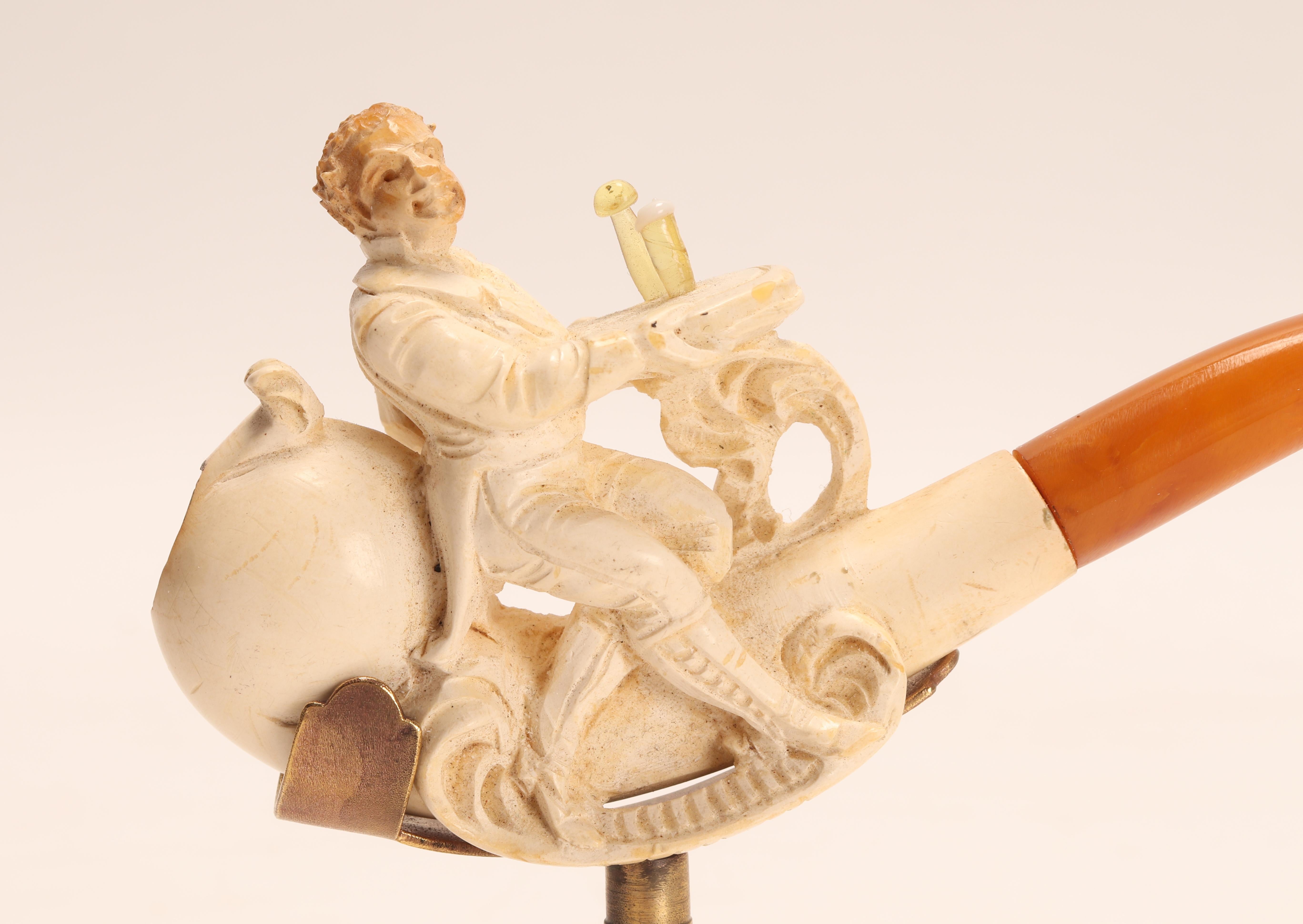 Tobacco taster pipe, made out of carved meershaum, with amber mouthpiece. A waiter with the face of a monkey, serves in a tray, a bottle and a mug of beer, made of amber. Original case. Vienna, Austria circa 1880. (The stand is for photographic use