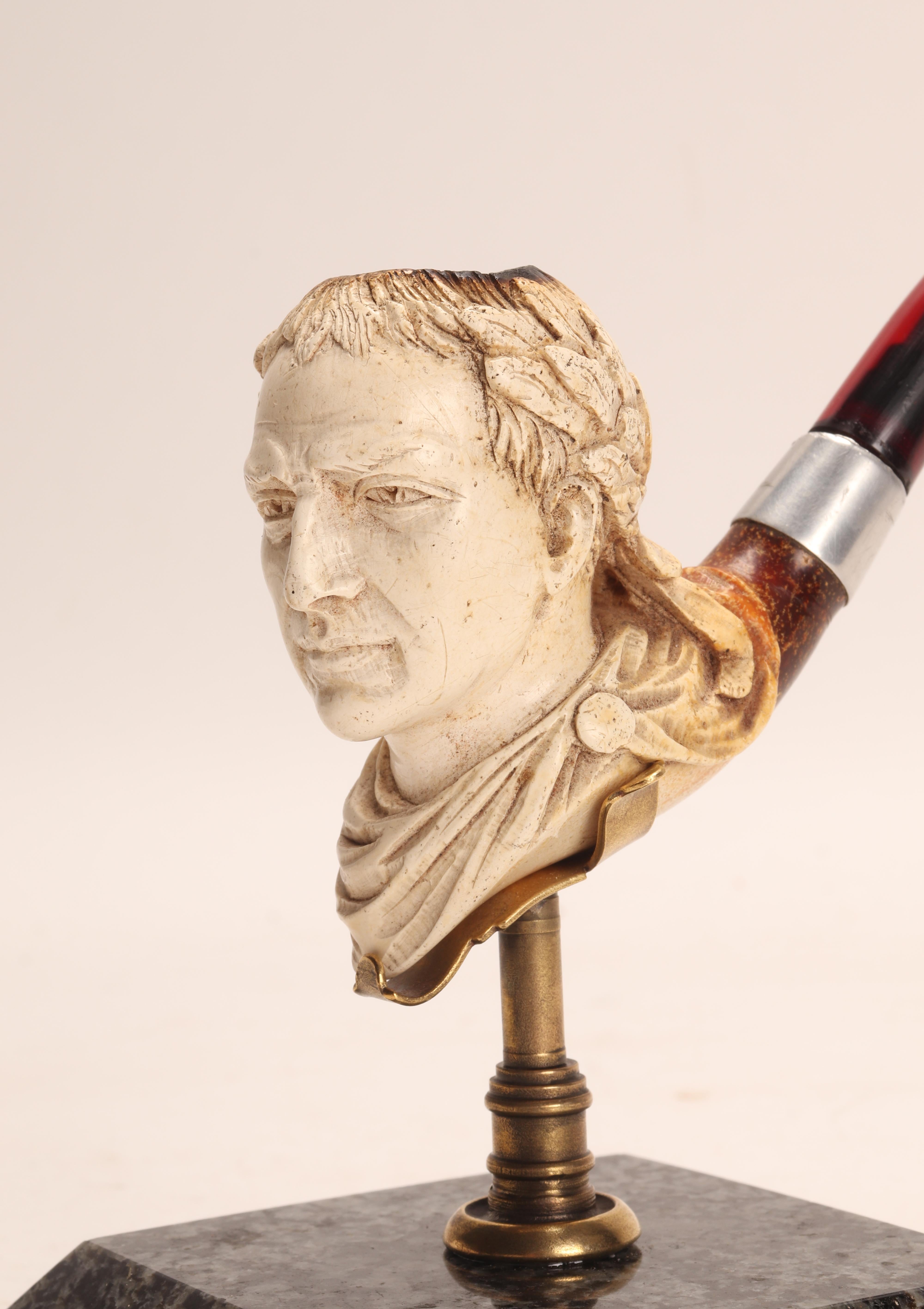 Carved meershaum pipe, with amber mouthpiece and silver band. In the bowl of the pipe, the head of the dictator Julius Caesar, is depicted with a laurel wreath on his head. Original case. Vienna, Austria circa 1880. (The stand is for photographic
