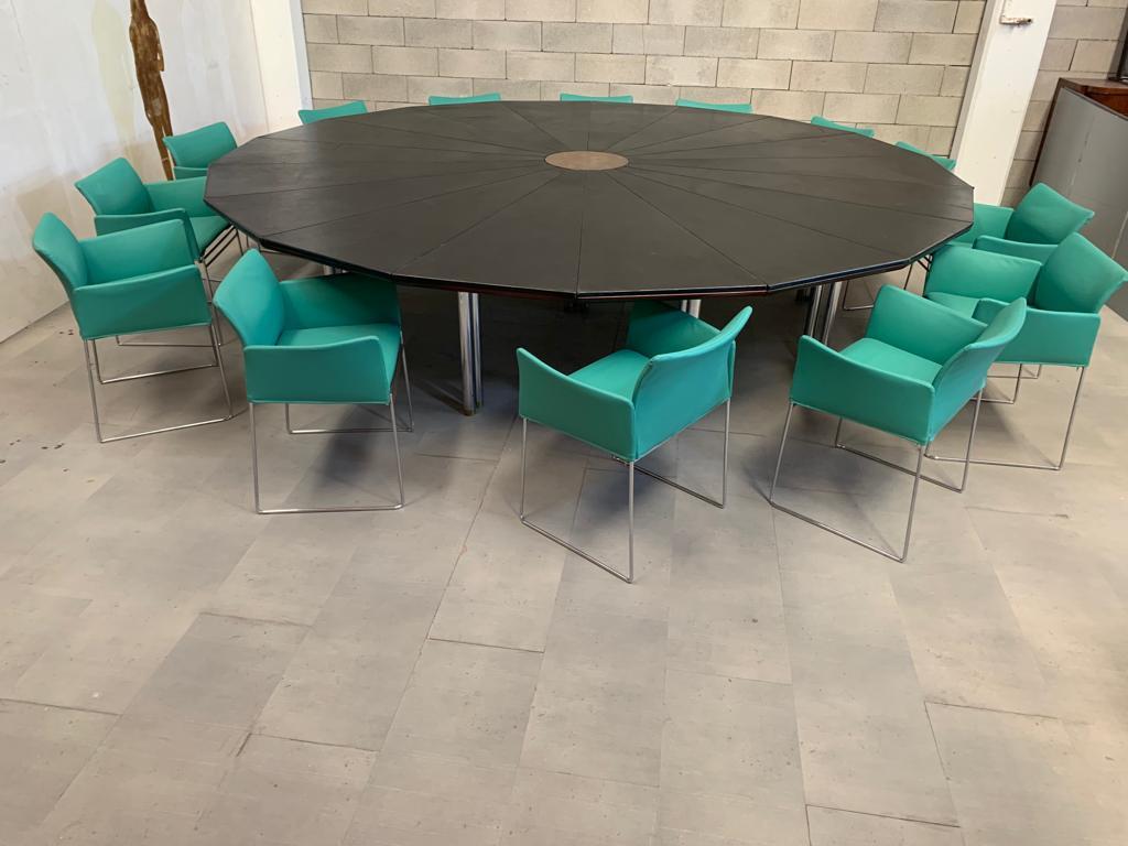 Set including meeting table and 14 seats.
Mod Bisanzio table by Hyroyuki Toyoda for Simon Gavina 1980, composed of 9 pairs of legs at the edges and 3 central ones in steel with a brass finish.
The 3.5 cm thick plywood top over wedges covered in
