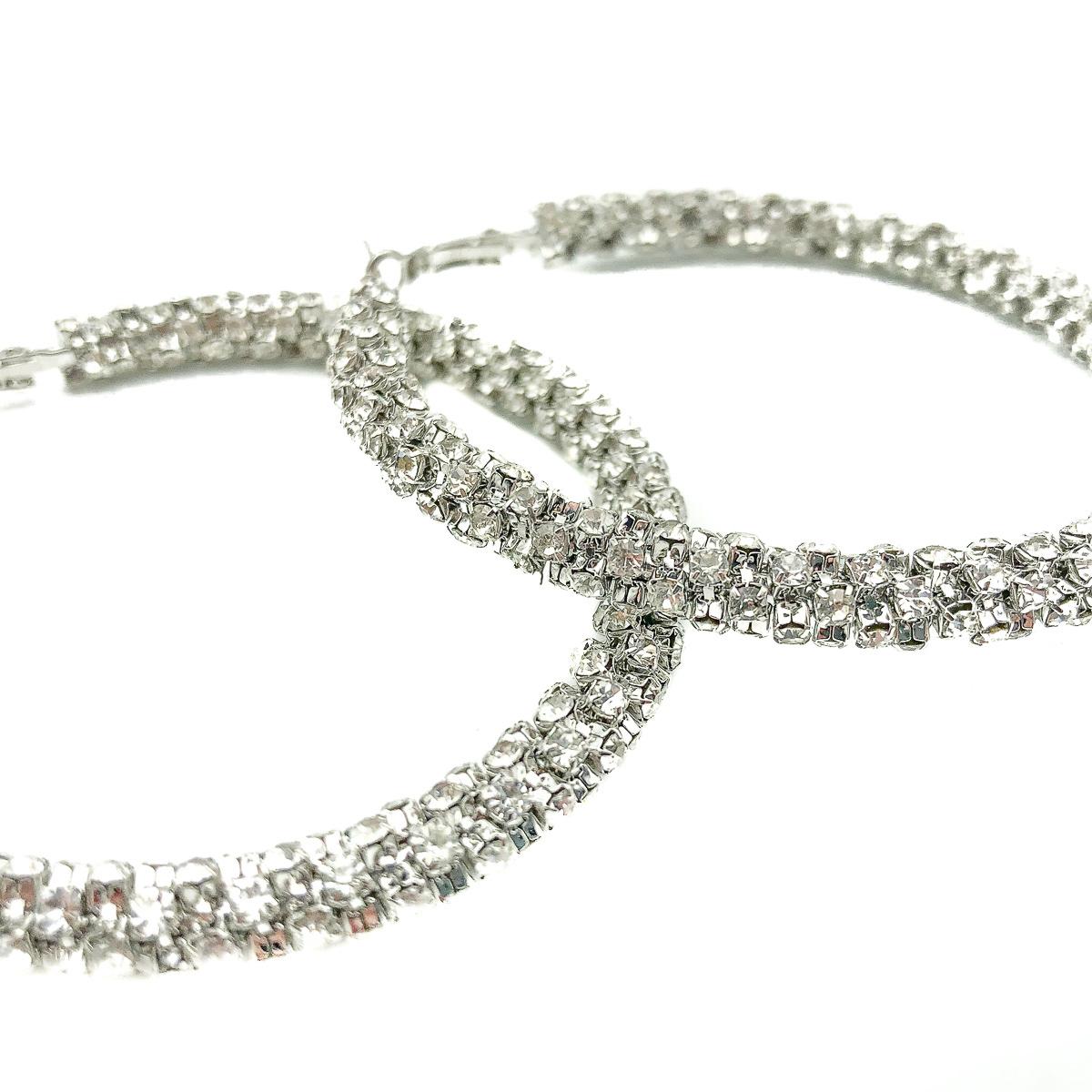 Oversize Crystal Hoop Earrings. Crafted in silver tone metal with heaps of claw set crystal chaton stones for full sparkle effect.  In very good condition, signed, approx. 6cms diameter. Channel your inner goddess and go for it. 

Established in