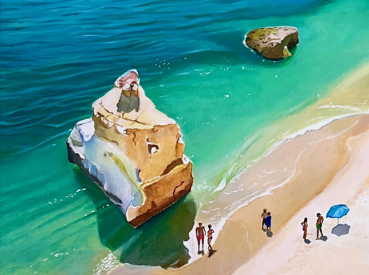 Umgeben von Kalksteinfelsen genießen Sonnenanbeter die Mittagssonne an der Küste Portugals.  Ein erhöhter Blick auf einen der berühmtesten Strände des Landes - den Praia de Marinha, wo die Einheimischen im Sand liegen und sich mit Freunden treffen.