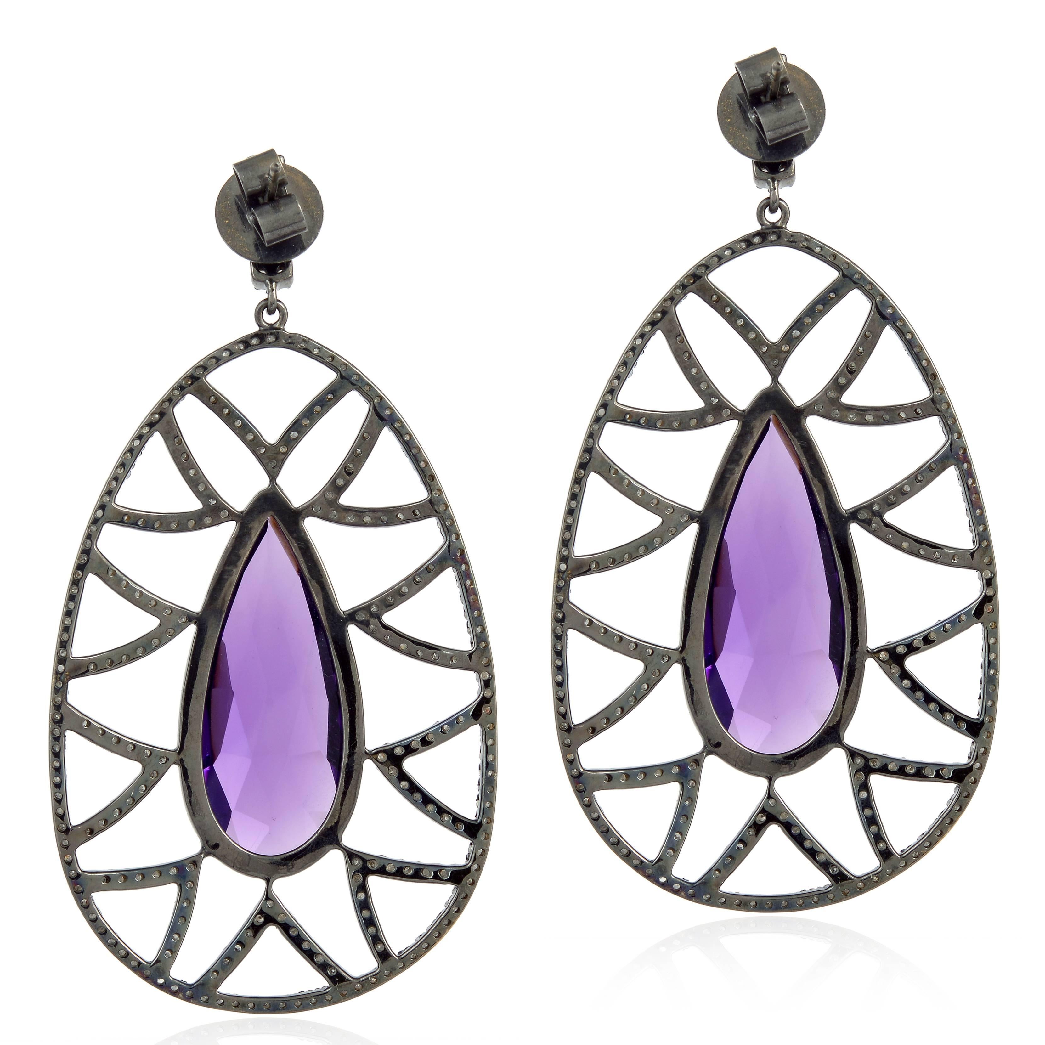 These earrings are cast in 18K gold and sterling silver.  It is hand set in 20.57 carat amethyst and 4.63 carat of sparkling diamonds. The negative space accentuates the main stone to create a dazzling dangle.  Complimentary conversion to clip-on