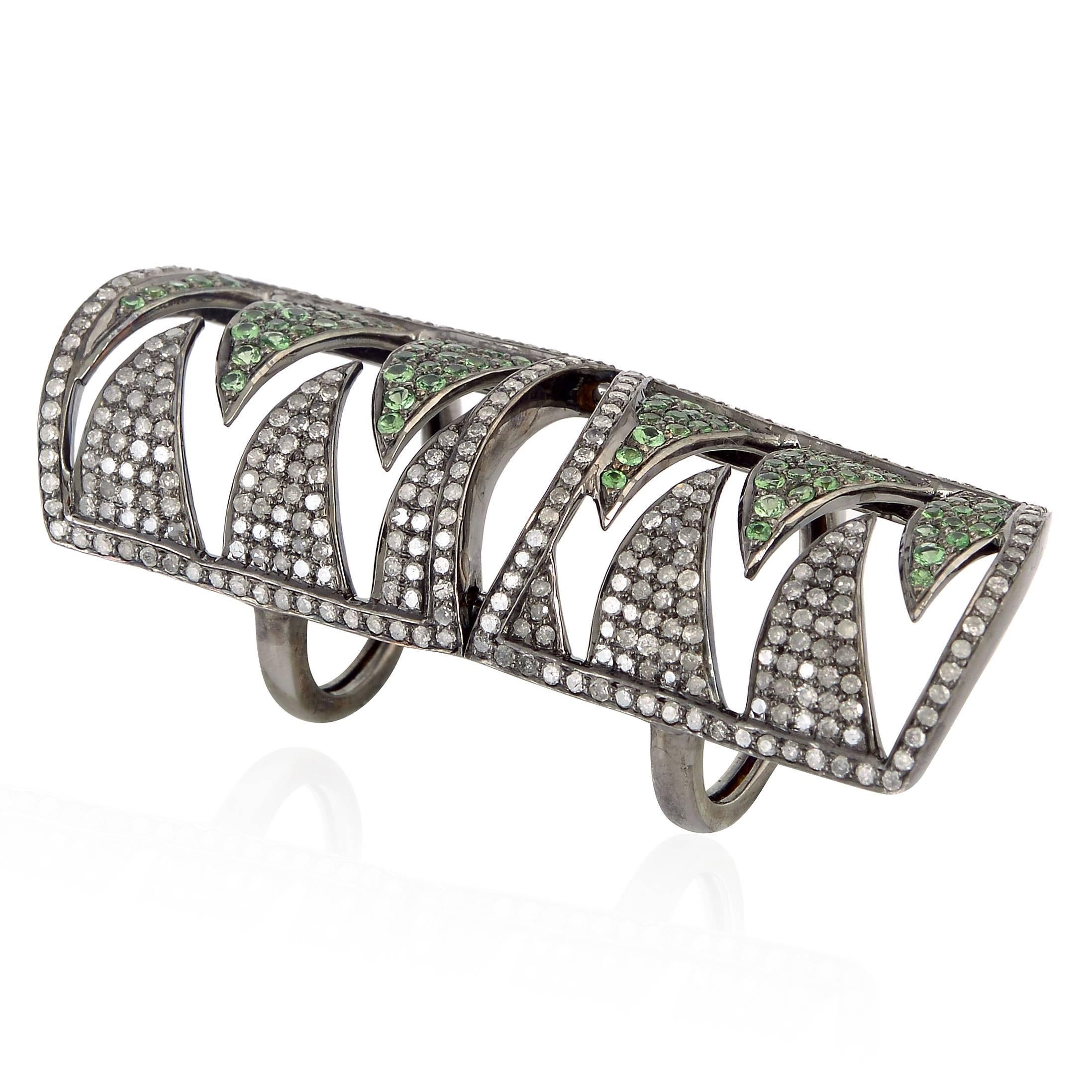 Handcrafted in 18K and sterling silver. It is set in 1.25 carat tsavorite and 1.90 carat diamonds. Wear this dramatic piece to add edge to feminine cocktail outfits. This ring has a hinged in center so it's comfortable when bending the finger.