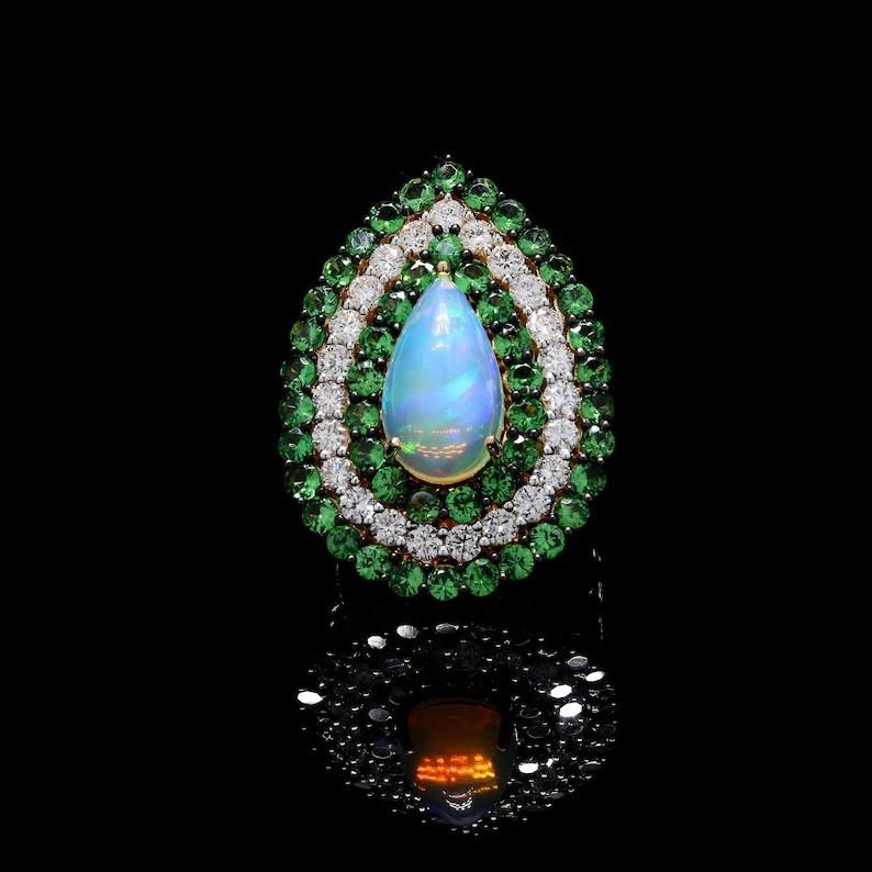 This exquisite ring is handcrafted in 14-karat gold. It is set in 5.91 carats Opal, tsavorite and 1.39 carats of sparkling diamonds.

FOLLOW MEGHNA JEWELS storefront to view the latest collection & exclusive pieces. Meghna Jewels is proudly rated as