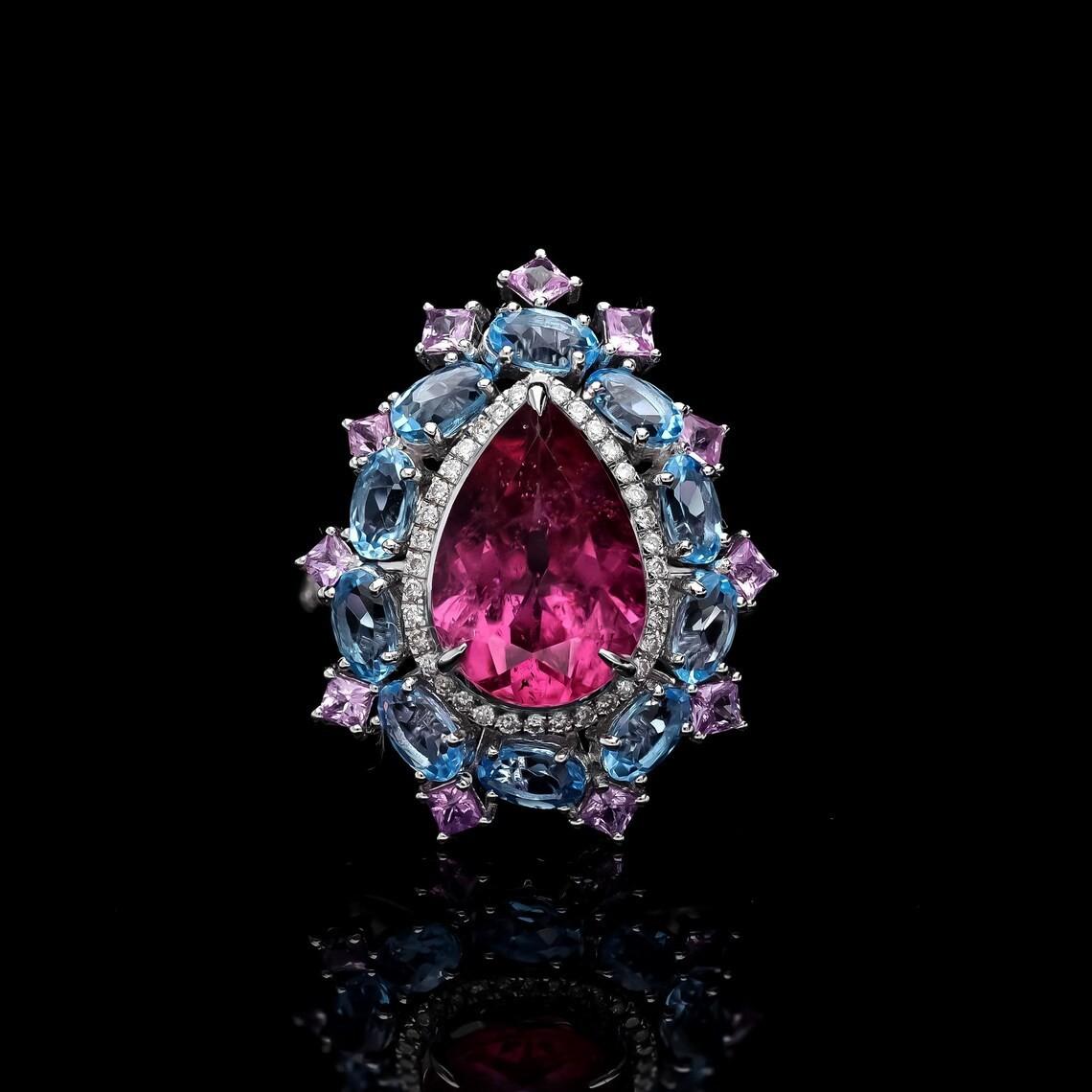 Questo squisito anello è realizzato a mano in oro a 18 carati. È incastonato con 7,91 carati di tormalina, topazio blu, zaffiro rosa e .32 carati di diamanti scintillanti.

SEGUITE la vetrina di MEGHNA JEWELS per vedere le ultime collezioni e i