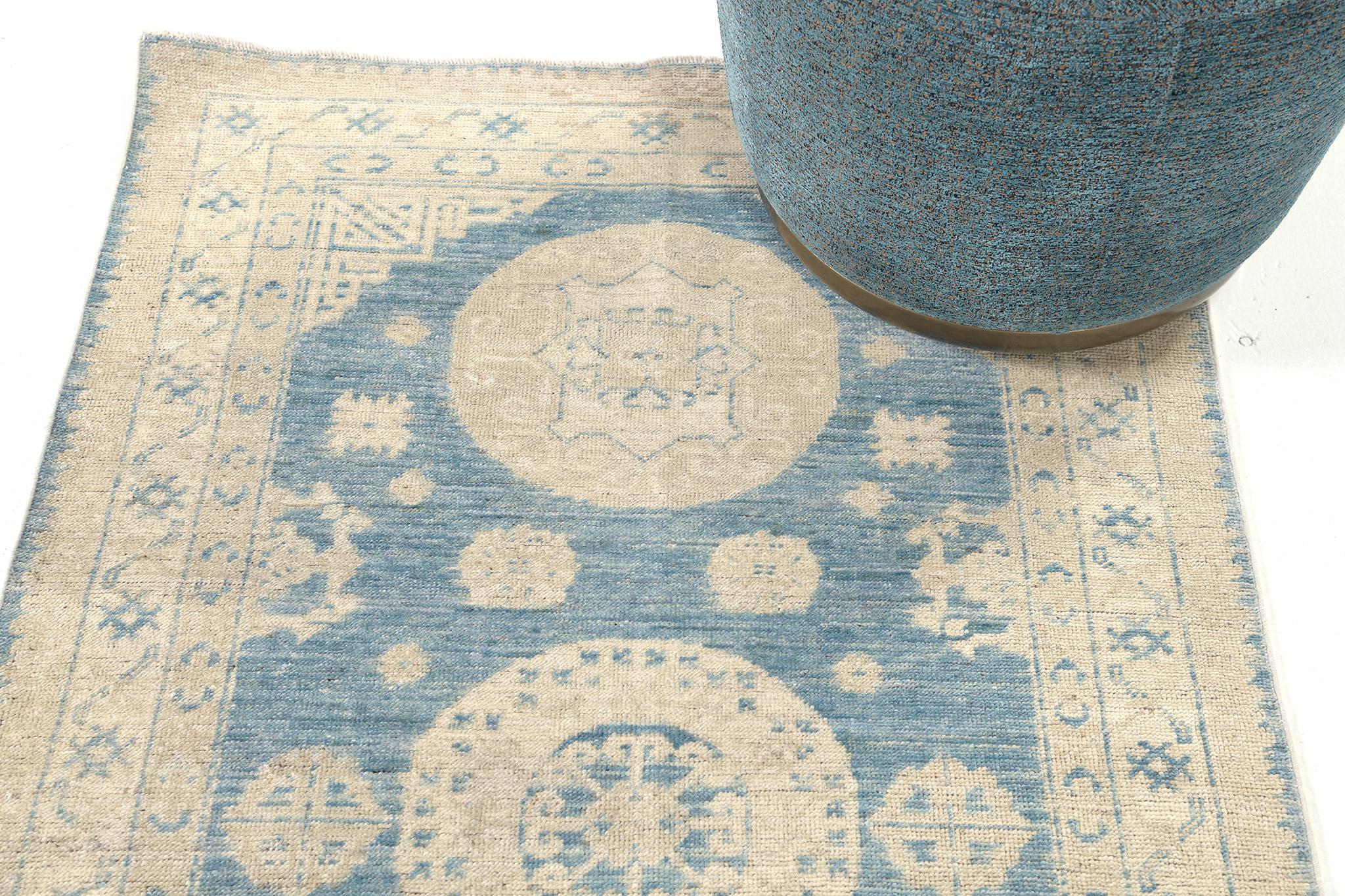 A majestic stylish Khotan revival rug that features a series of symbollical medallions spread across the cobalt field. Glorious ornate eye motifs enclose this sophisticated rug. An undeniably mesmerizing rug that brings incomparable elegance to