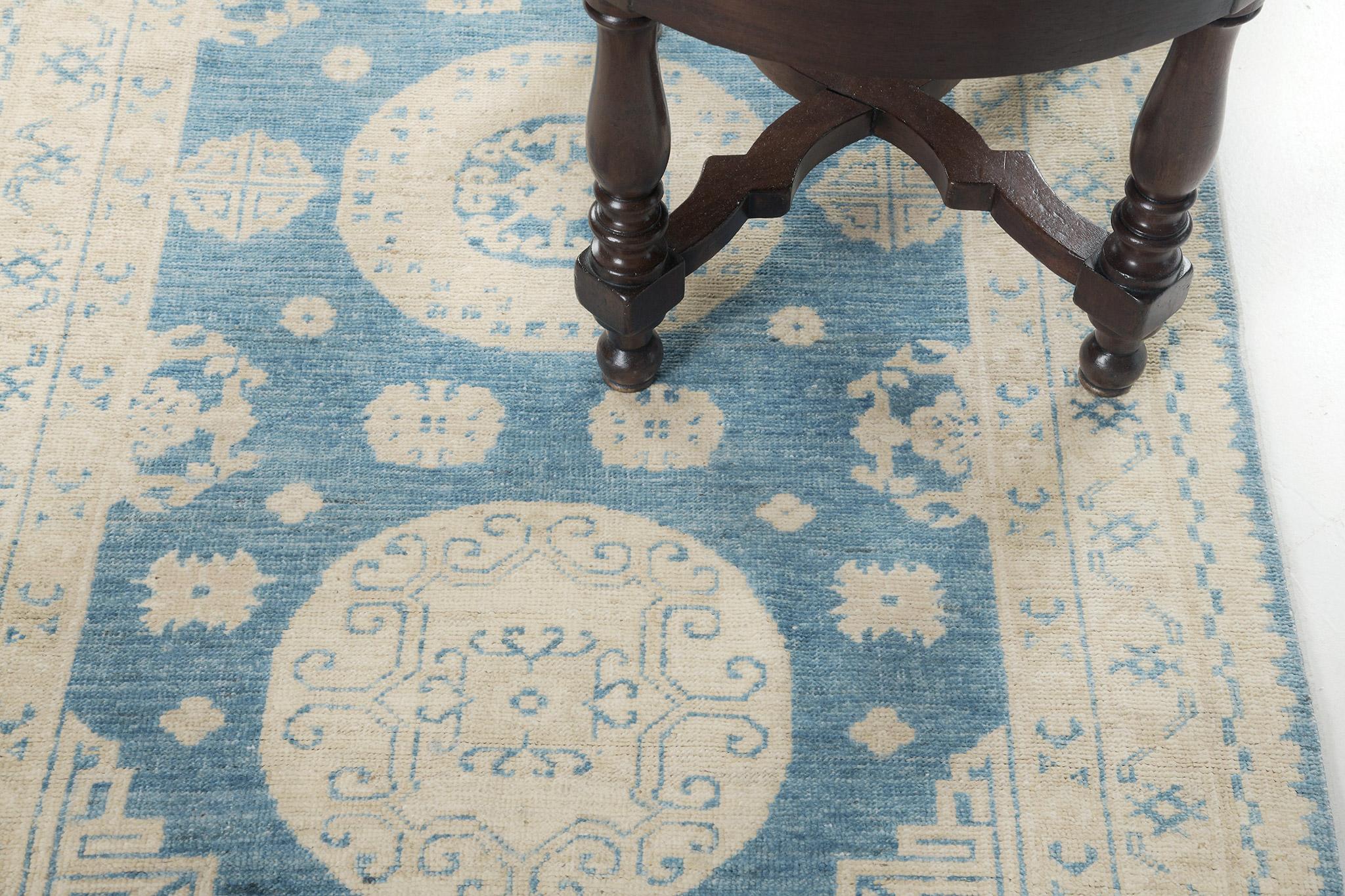 This impressive Khotan Design Rug is ideally suited for a floor piece. Three grandiose medallions are perfectly filled with scattered florid elements. From gorgeous patterned borders to the cerulean blue field, it complements every single detail to