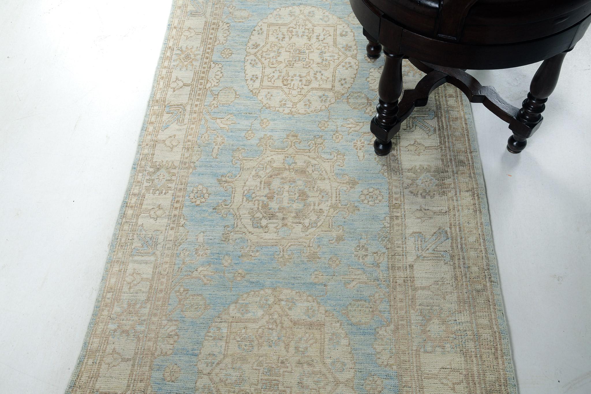 Our most impressive revived Khotan design rug of the Safira Collection is perfect for your home spaces. It will prove its versatility through its striking blue hues that turned into notable details and patterns. A neutral-toned field has its