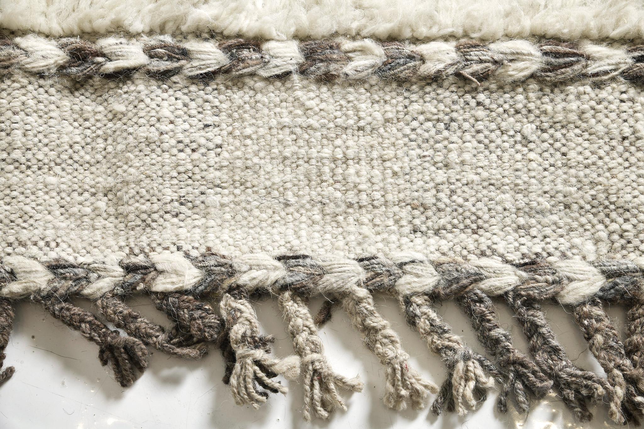 Abrolhos est un tapis de laine luxueux tissé à la main avec des détails en relief intemporels. En plus de son tissage plat ivoire parfait, Albrohos possède un magnifique shag qui apporte une texture lustrée et une sensation contemporaine à l'espace.