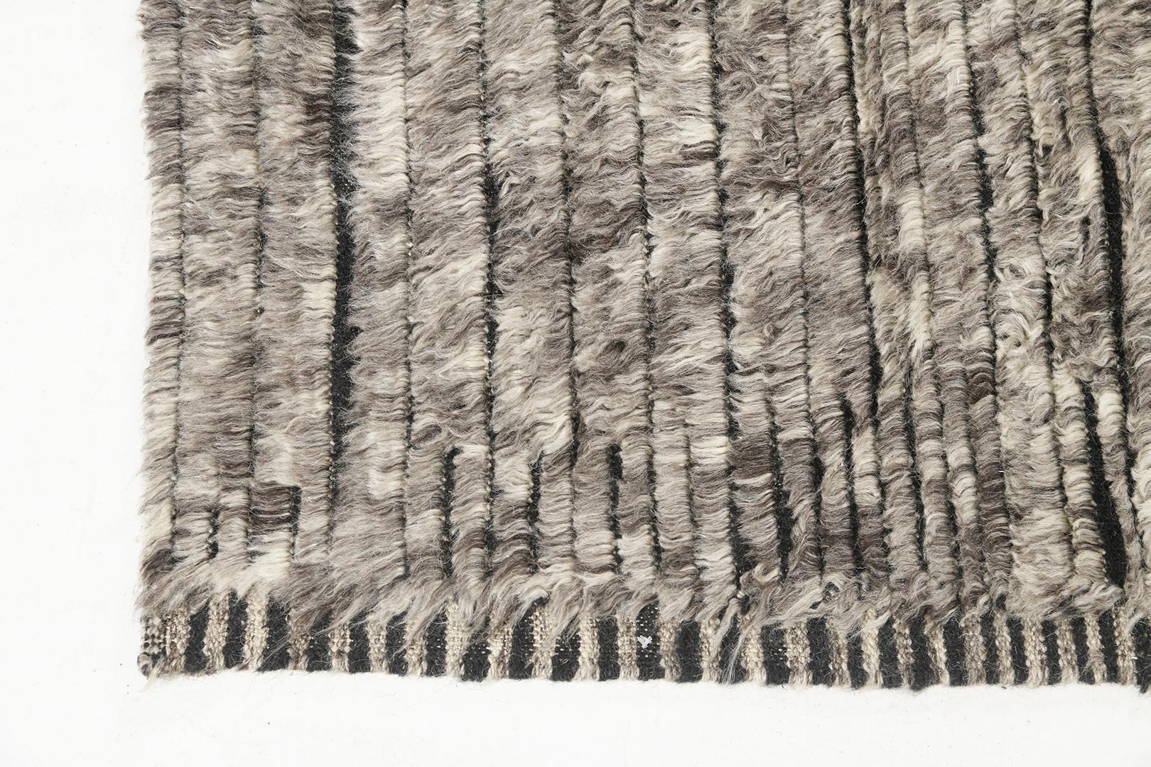 L'Abroshca è un tappeto in lana intrecciata a mano con dettagli verticali in rilievo senza tempo. Oltre alla sua perfetta trama a vello grigio, Abroshca ha un elegante effetto shag che conferisce una texture lucente e un'atmosfera contemporanea al