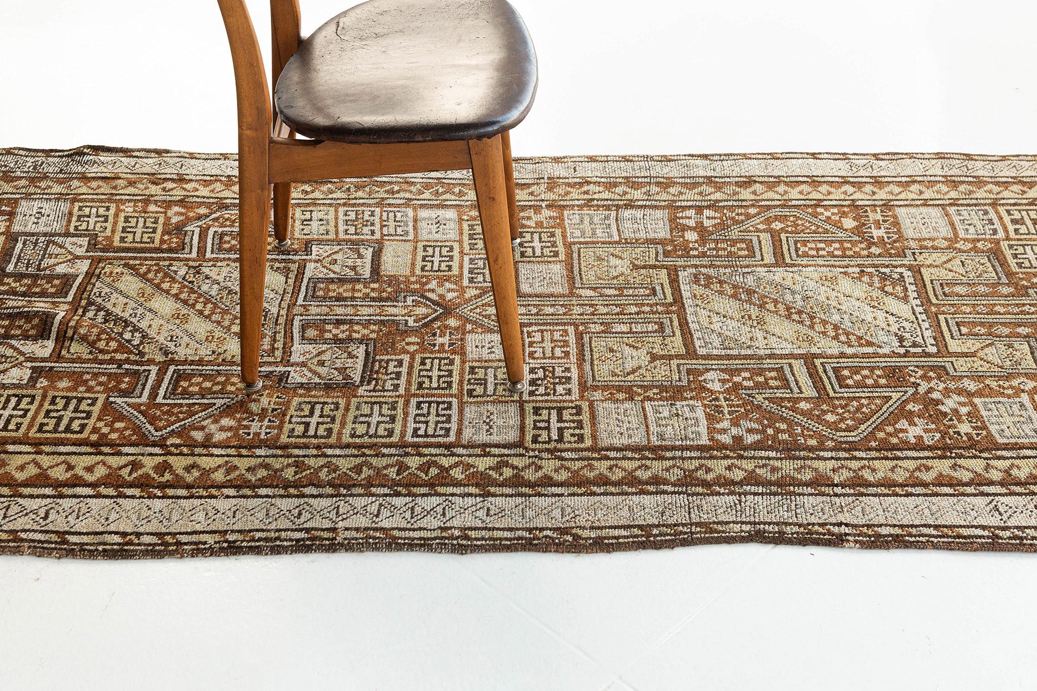 An antique Caucasian Kazak runner with brown and gold colors with a mesmerizing beautiful finish. This rug is distinctly tribal and geometric and yet the color way creates an overall effect that is soft and subdued. With is lavish, brilliant color