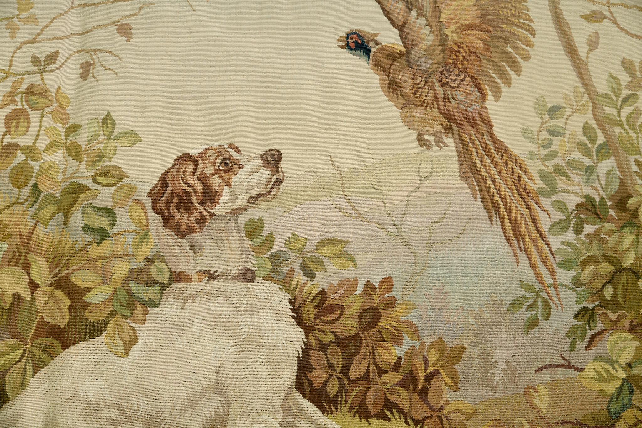 With its timeless sophisticated details of gold, neutral, green, and brown, this antique French Tapestry illustrates a playing dog and bird. A flatweave wool material is a brilliant complement to the palettes chosen. Not just a centerpiece but