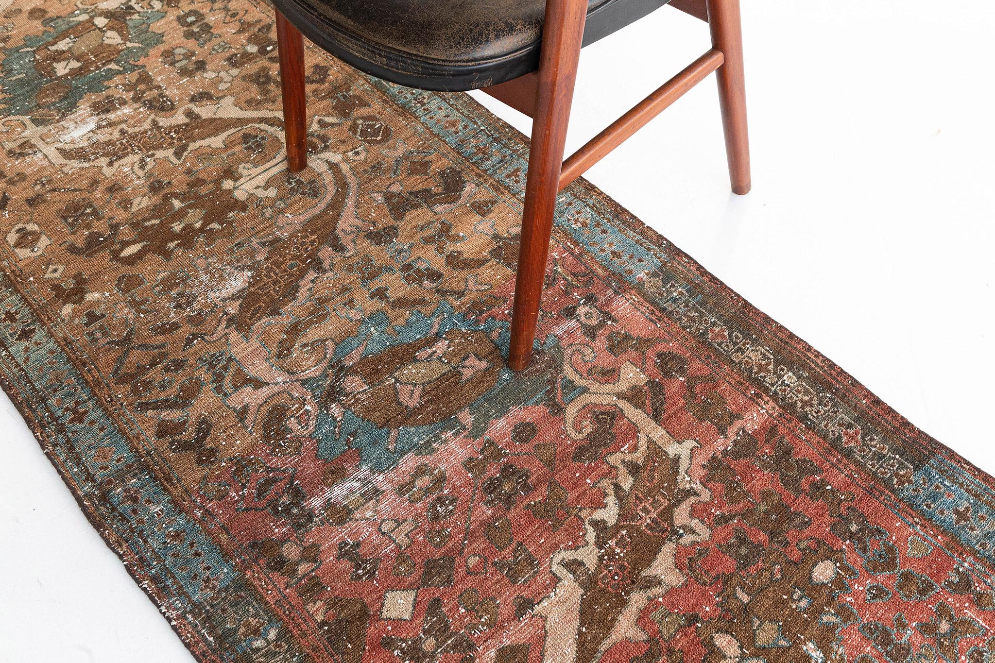 A mesmerizing antique Persian Lilihan runner that emanates a balanced and timeless floral design with a lovingly timeworn patina. The abrashed tawny field is covered with an all-over botanical pattern composed of blooming palmettes, serrated leaves,