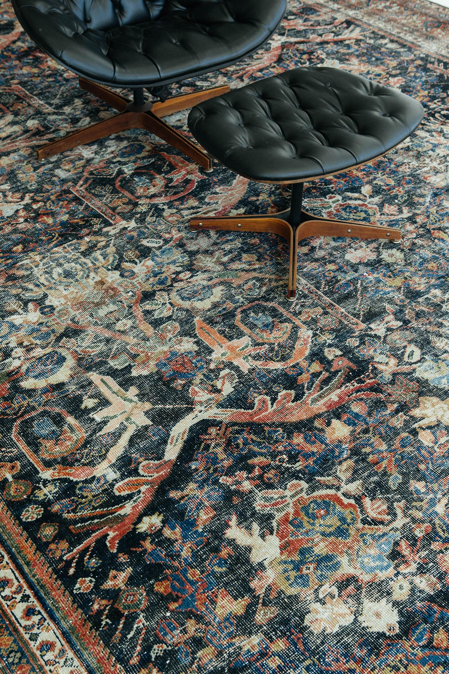 Questo tappeto persiano Mahal contiene motivi floreali, ramoscelli e motivi impressionanti in vari colori come rosso, verde, blu e beige, su uno sfondo nero. Un magnifico bordo a tema naturalistico presenta diversi motivi floreali che si alternano