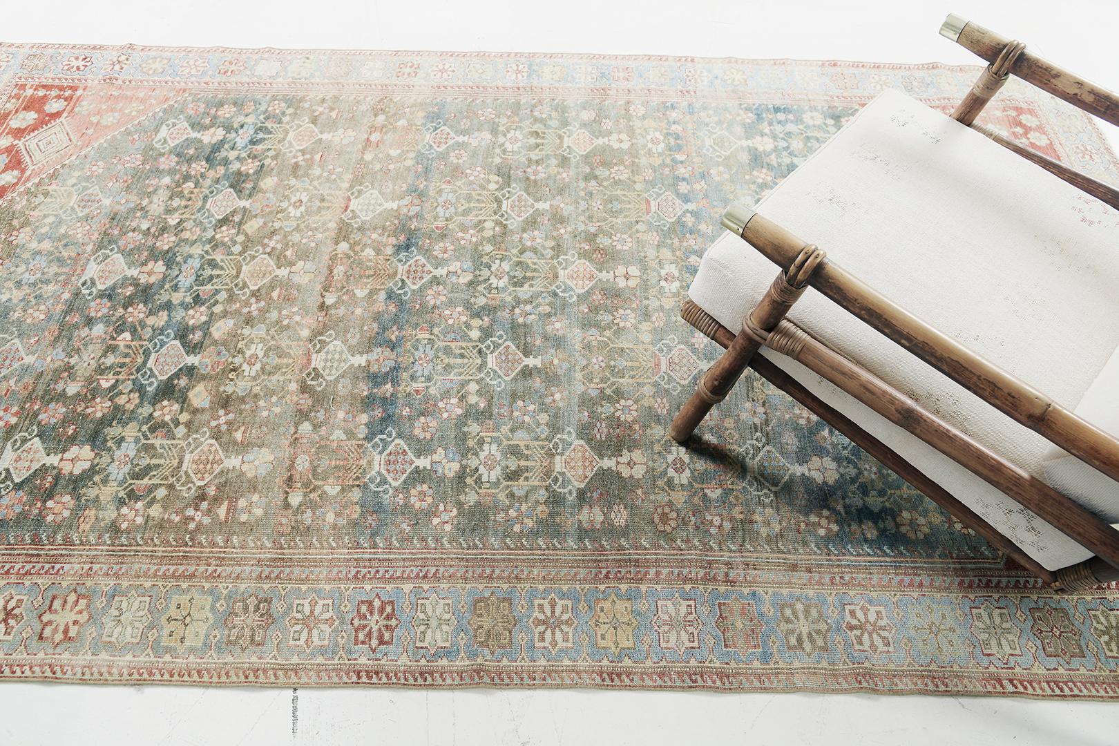 With its sophisticated vibe and impressive time-worn appeal, this antique Persian Malayer rug embodies a rustic botanical style. It features a dance of dainty florid elements that are graciously spread across the deep sea green abrashed.