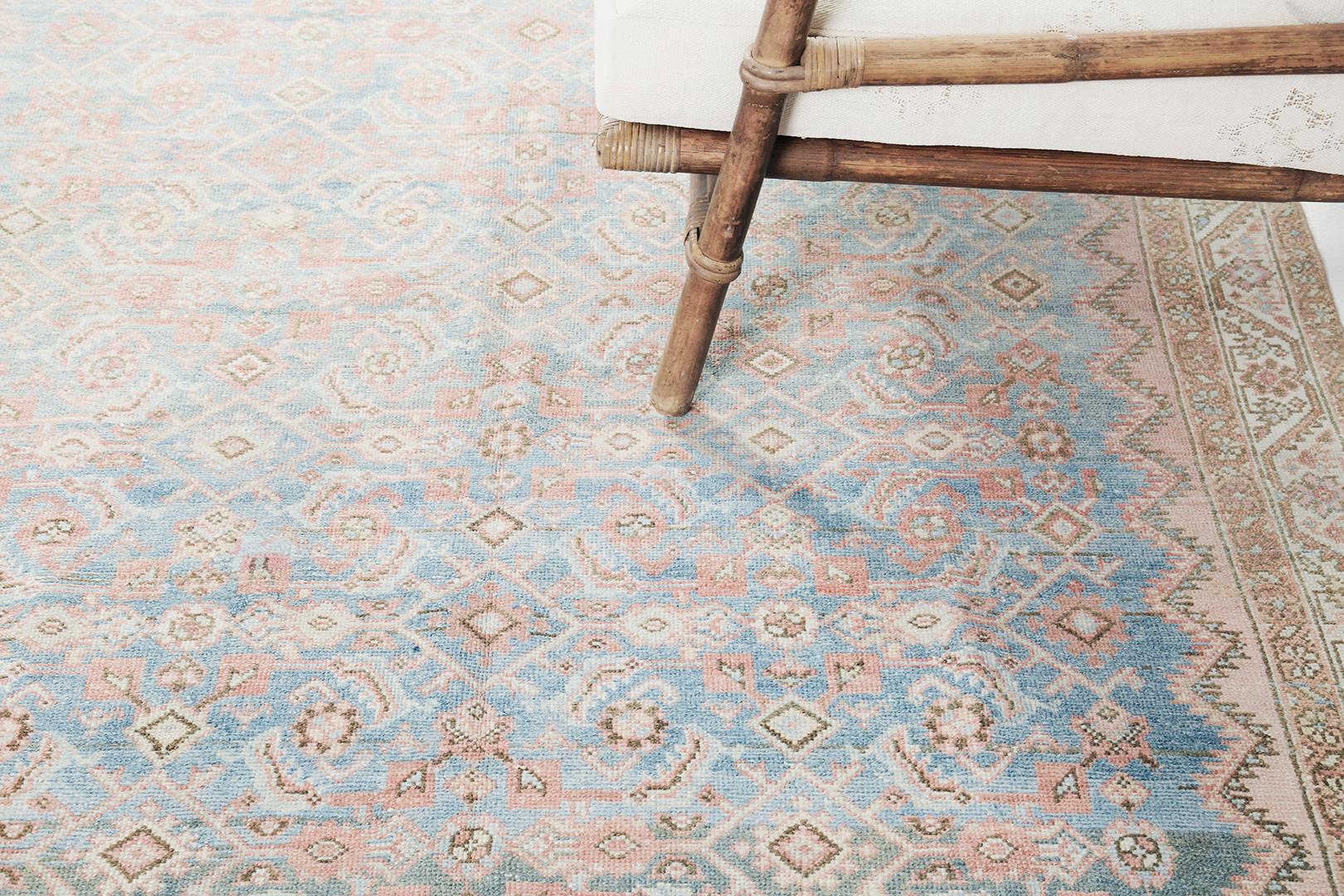 Un majestueux tapis de couloir persan ancien Malayer qui présente une variété d'éléments floraux sur toute sa surface, composés de motifs Herati, de fleurs stylisées et de feuilles dentelées fleurissant gracieusement un champ d' azur abrégé. Entouré