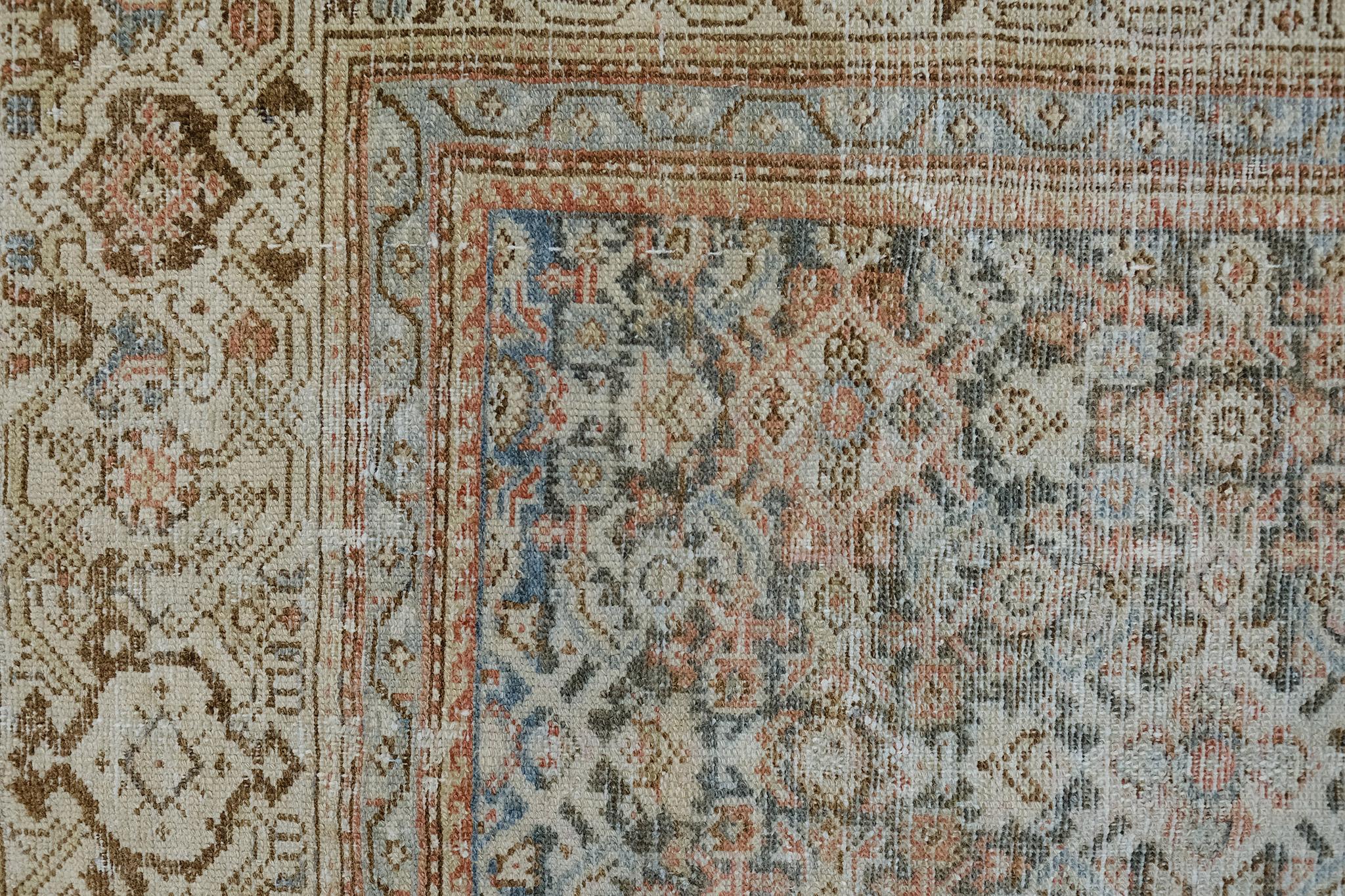 With its elegant vibe and impressive time-worn appeal, this antique Persian Malayer rug embodies a rustic botanical style. It features a dance of dainty florid elements that are graciously spread across the turquoise abrashed field. Effortlessly