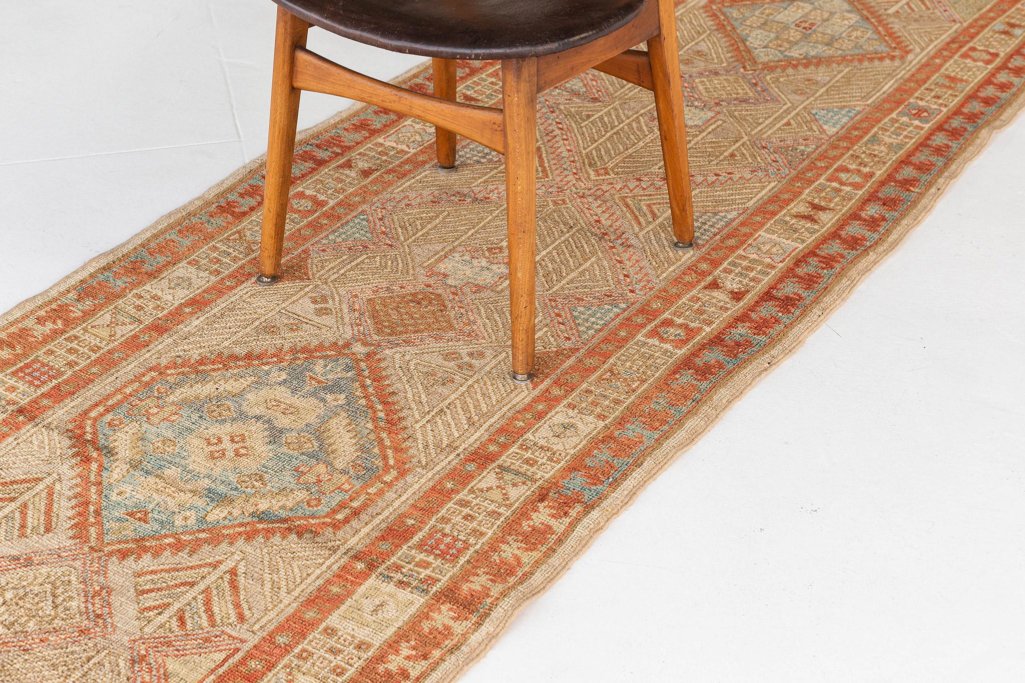 A fabulous Persian Malayer Runner that boasts its dazzling design. Centrally focused in its intricate composition of geometric motifs and linear composition, this majestic rug features the warm and vibrant tones of gold and teracotta. The attention
