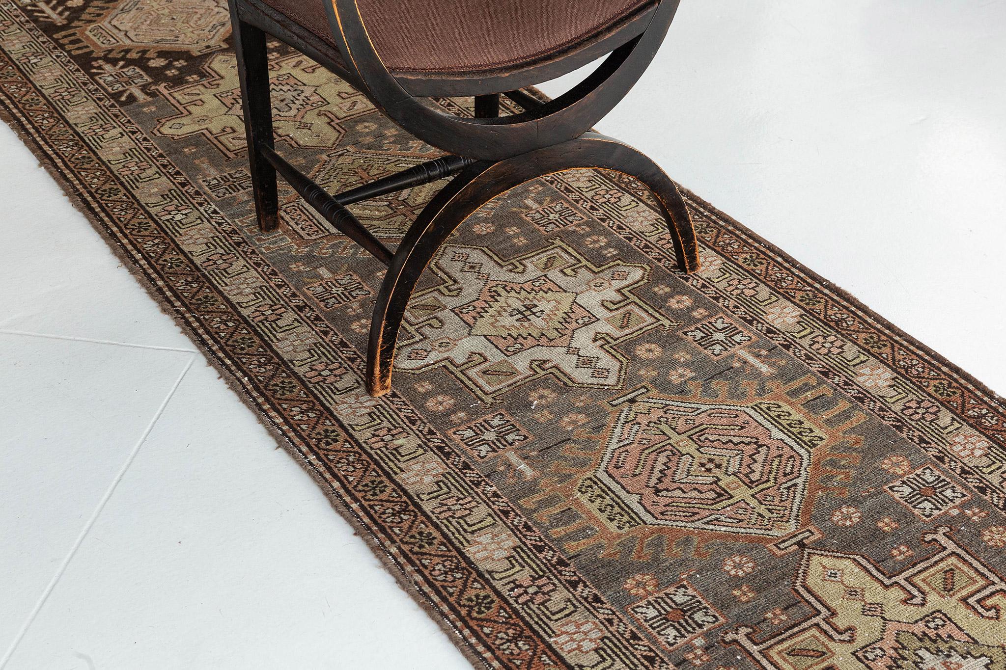 Emanating exquisite grace and majestic architectural design elements, this lovingly time-worn Persian Serapi Runner can gorgeously blend with modern, contemporary and traditional interiors. It features alternating series of lozenge and octogram