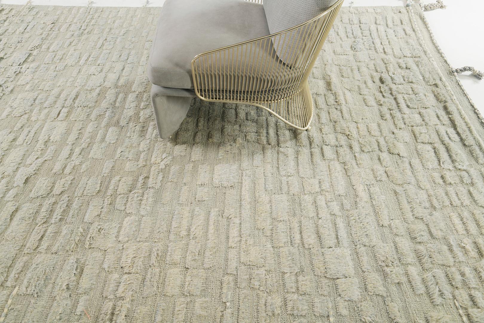 Charming and minimalistically elegant, Arezqi rug from Atlas Collection displays uneven ecru rectangles that stack together creating an enchanting effect radiating on the entirety of this wonderful rug. Spread graciously along the taupe field,