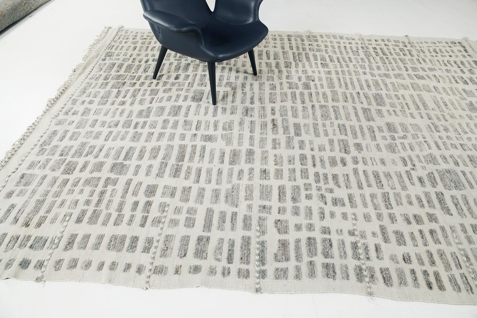 Charming and minimalistically elegant, Arezqi rug from Atlas Collection displays uneven taupe rectangles that stack together creating an enchanting effect radiating on the entirety of this wonderful rug. Spread graciously along the ecru field,