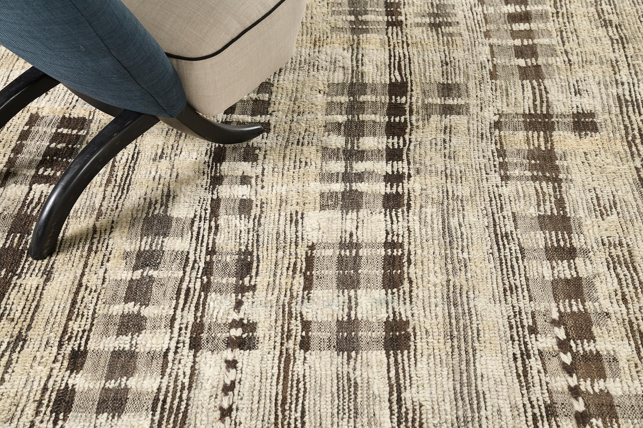 Baccata uses linework and color to create definition and movement into handwoven wool. Line detailing in taupe and umber brown fascinatingly move across the rug. Detailed natural flatweave runs around the border with tassels adding an exquisite