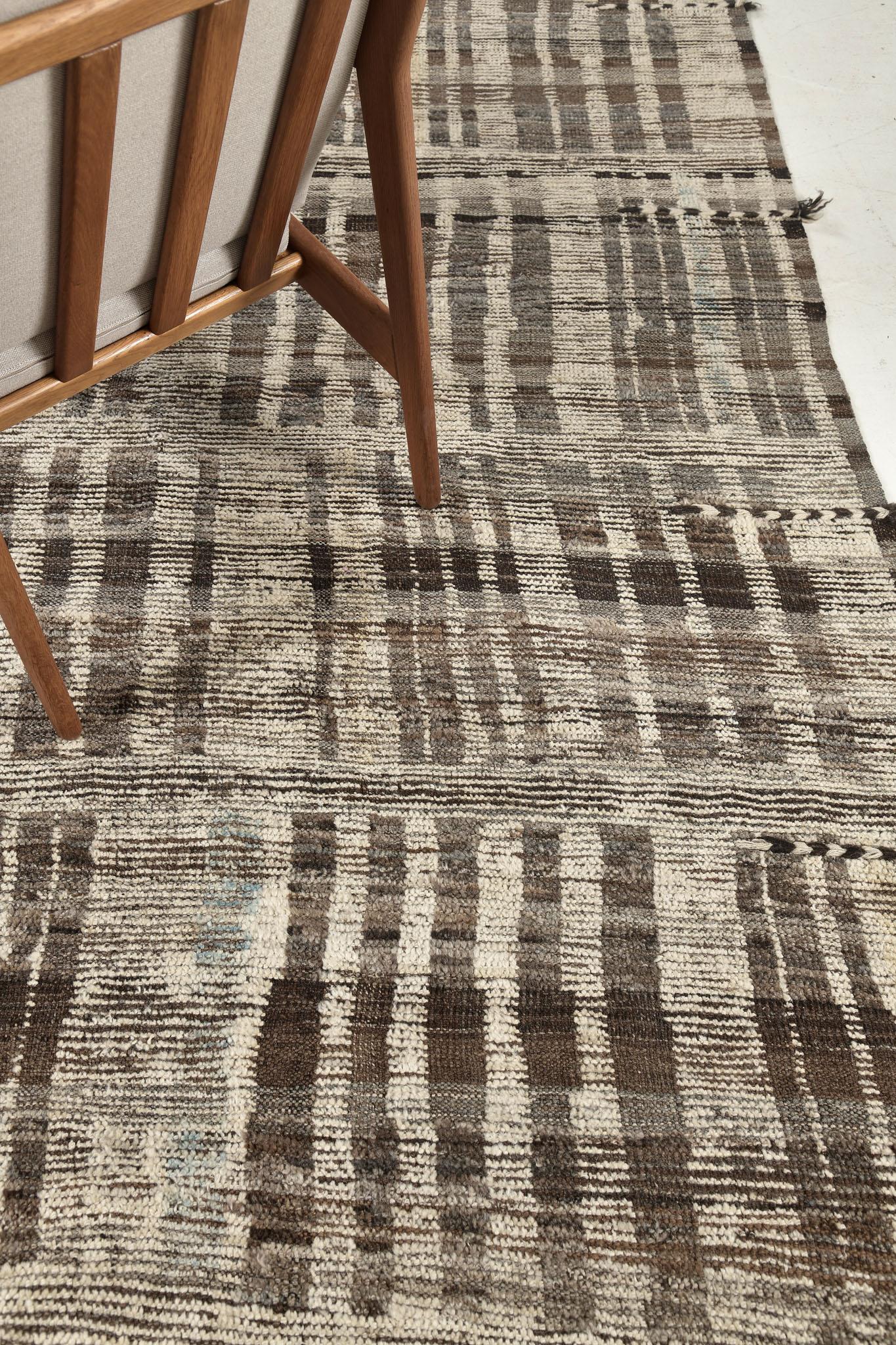 Bacatta uses linework and color to create definition and movement in handwoven wool. Line detailing in neutral tones fascinatingly moves across the rug. Detailed natural flatweave runs around the border with tassels adding an exquisite decorative