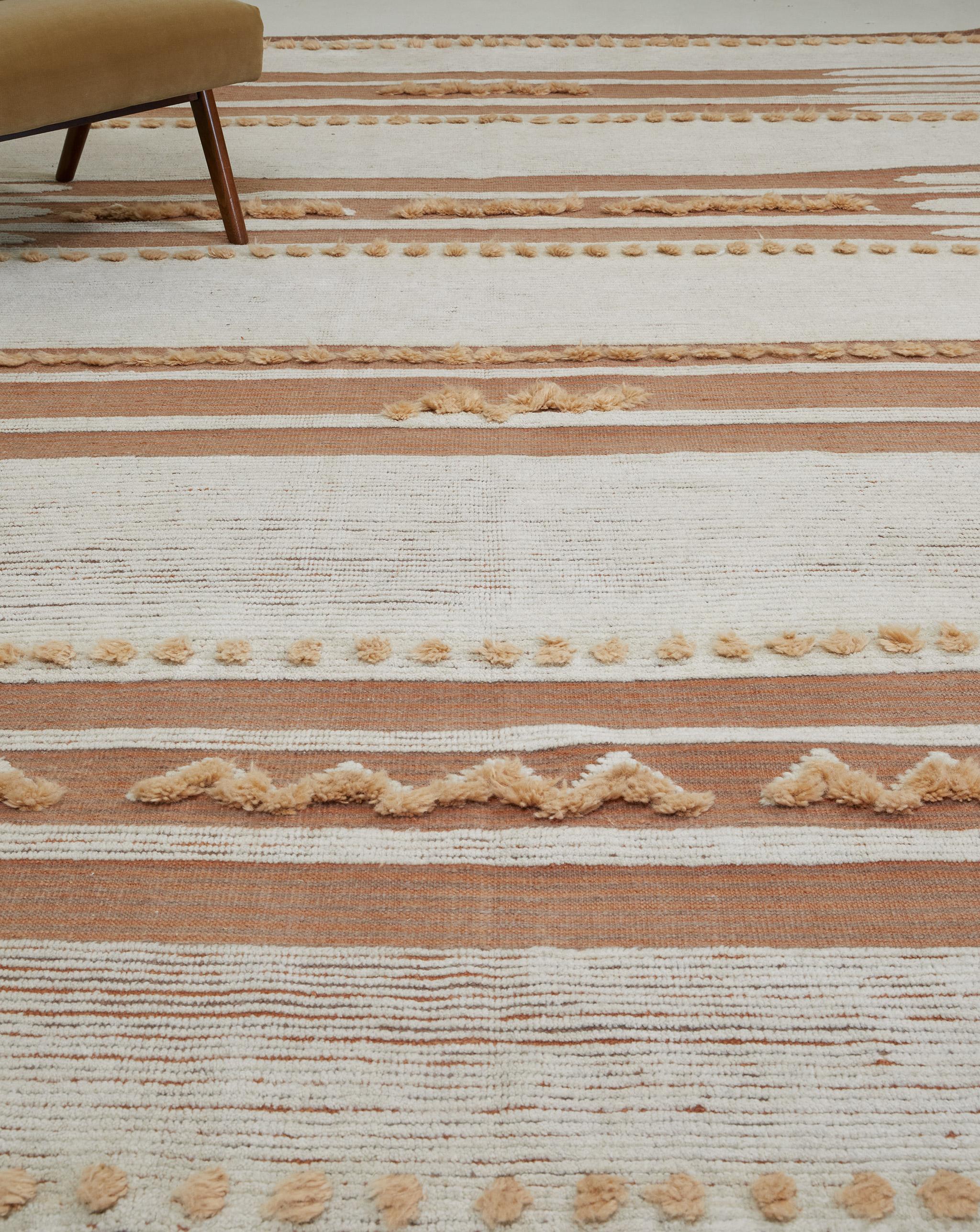 Composed of horizontal bands with revealed flatweave, Barbera brings the fun with tactile accent poofs and a few zigzags. 

Here in spicy mandarin with ivory and a touch of apricot.

The Estancia Collection by Mehraban is a group of casually