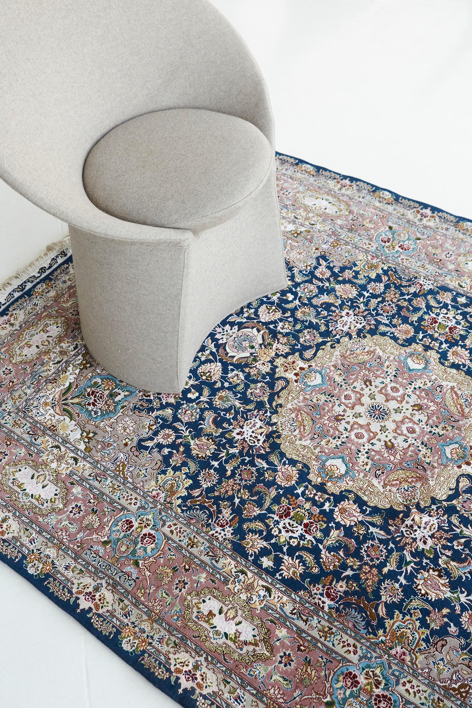A laudable Fine Persian Tabriz rug features all the blooming elements that intensify into a midnight blue field. The main border contains an all-over lattice of issuing split leaves, mini palmettes, and a delicate flowering vinery that makes the rug