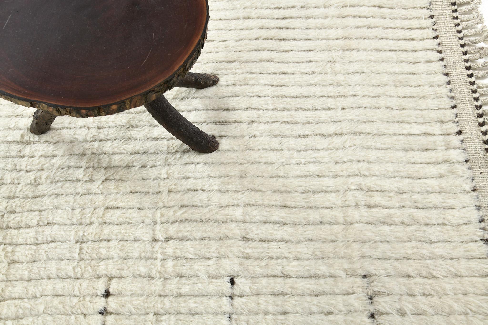 Fohn' is a handwoven luxurious wool rug with dainty embossed line detailing. In addition to its ivory toned flat-weave, Fohn has a perfect shag that brings a radiant and contemporary feel to one's space. The Haute Bohemian collection is designed in