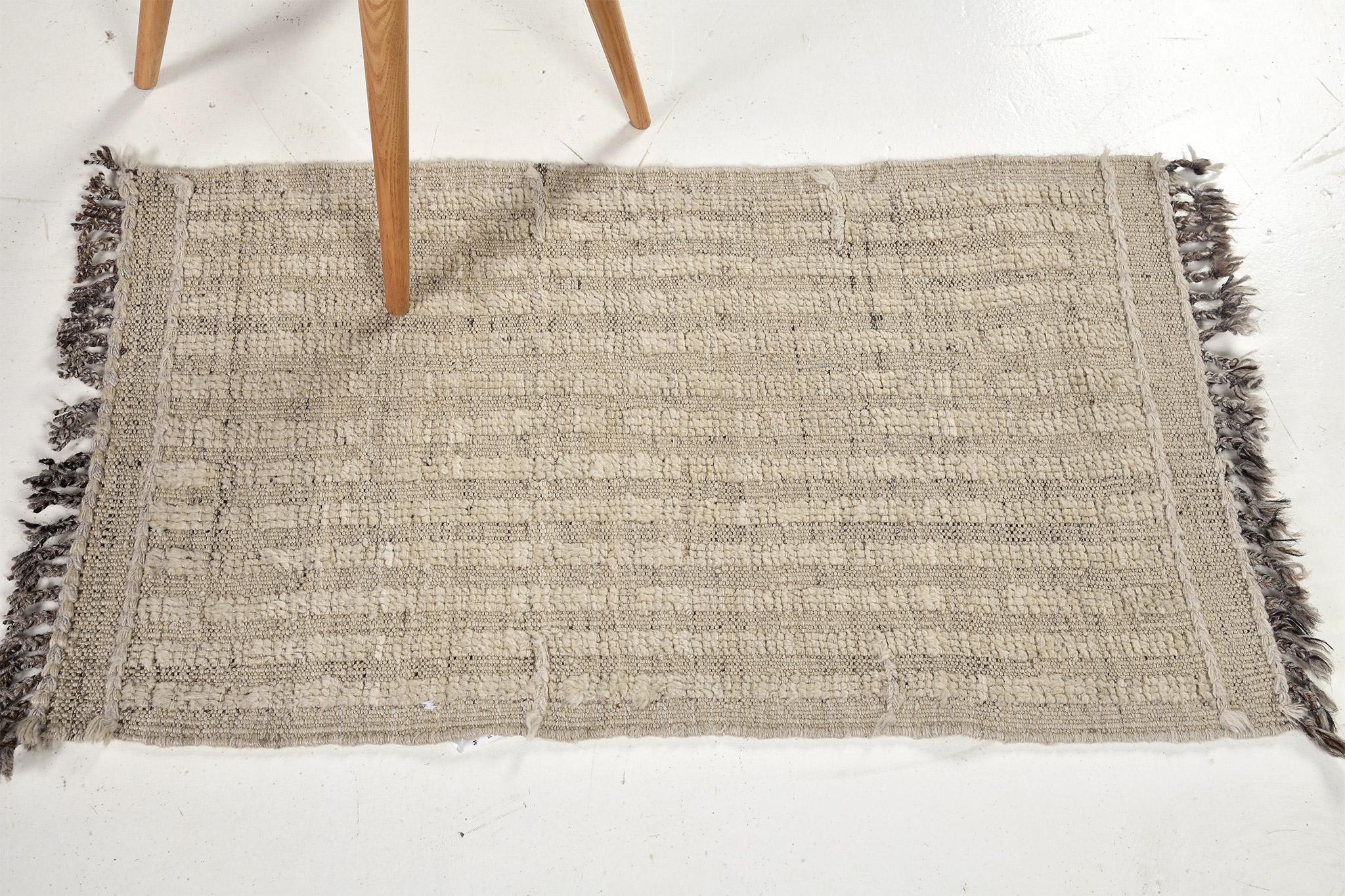 Fohn' is a handwoven luxurious wool rug with dainty embossed line detailing. In addition to its beige toned flat-weave, Fohn has a perfect shag that brings a radiant and contemporary feel to one's space. The Haute Bohemian collection is designed in