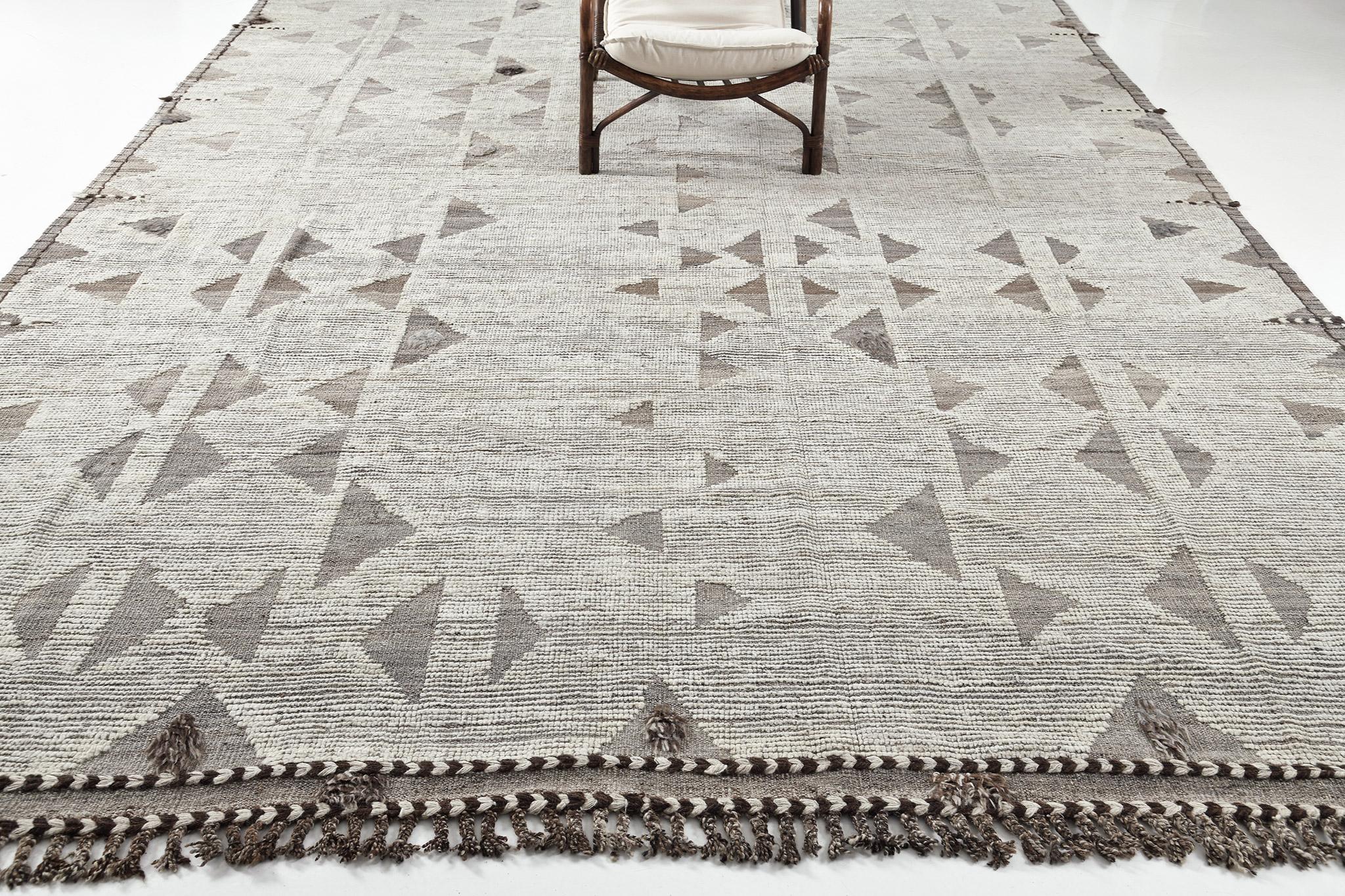Gimbrala' is a stunning handwoven natural ivory rug with embossed triangle detailing surrounding the perfect gray pile. Beautiful tassels and bordered designs add a timely and one of a kind essence for the modern design world. Haute Bohemian