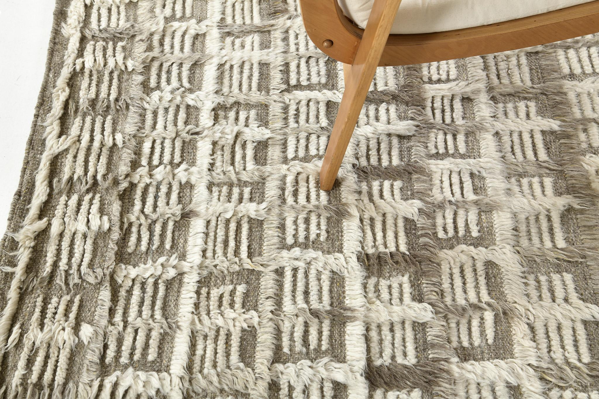 Der Teppich Hanin ist ein komplexes, mehrfarbiges Rastermotiv in langen Florlinien mit Formen von Zierflor und offenen Flachgewebe-Akzenten. Hanin ist hier in einem weichen Kakaobraun mit knackigen elfenbeinfarbenen Elementen wiedergegeben.

Die