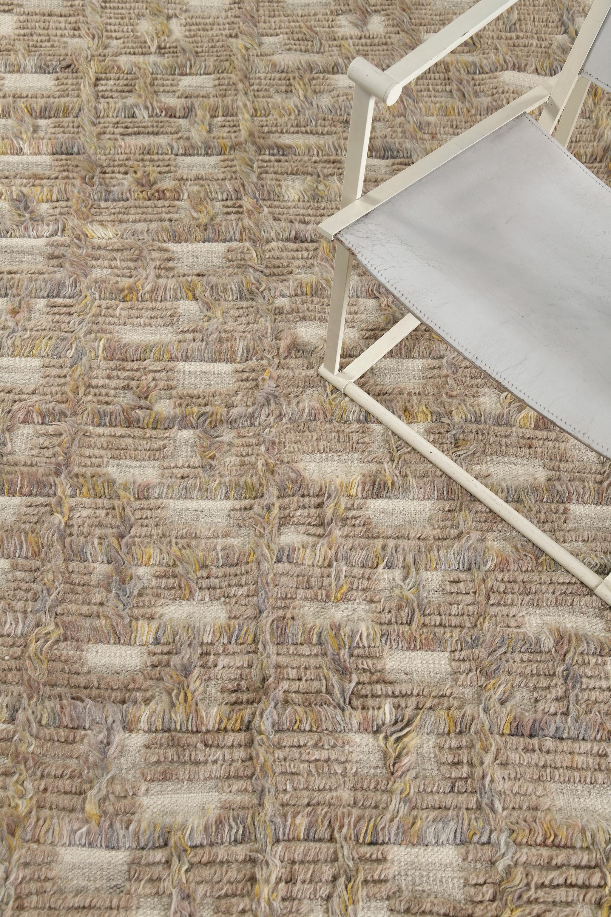 Imana is an intricate syncopated motif of long and short pile punctuated by squares of open flatweave in banded tones. Imana is available in two colorways, with custom options available. This piece features heathered clay-taupe colors, with dappled