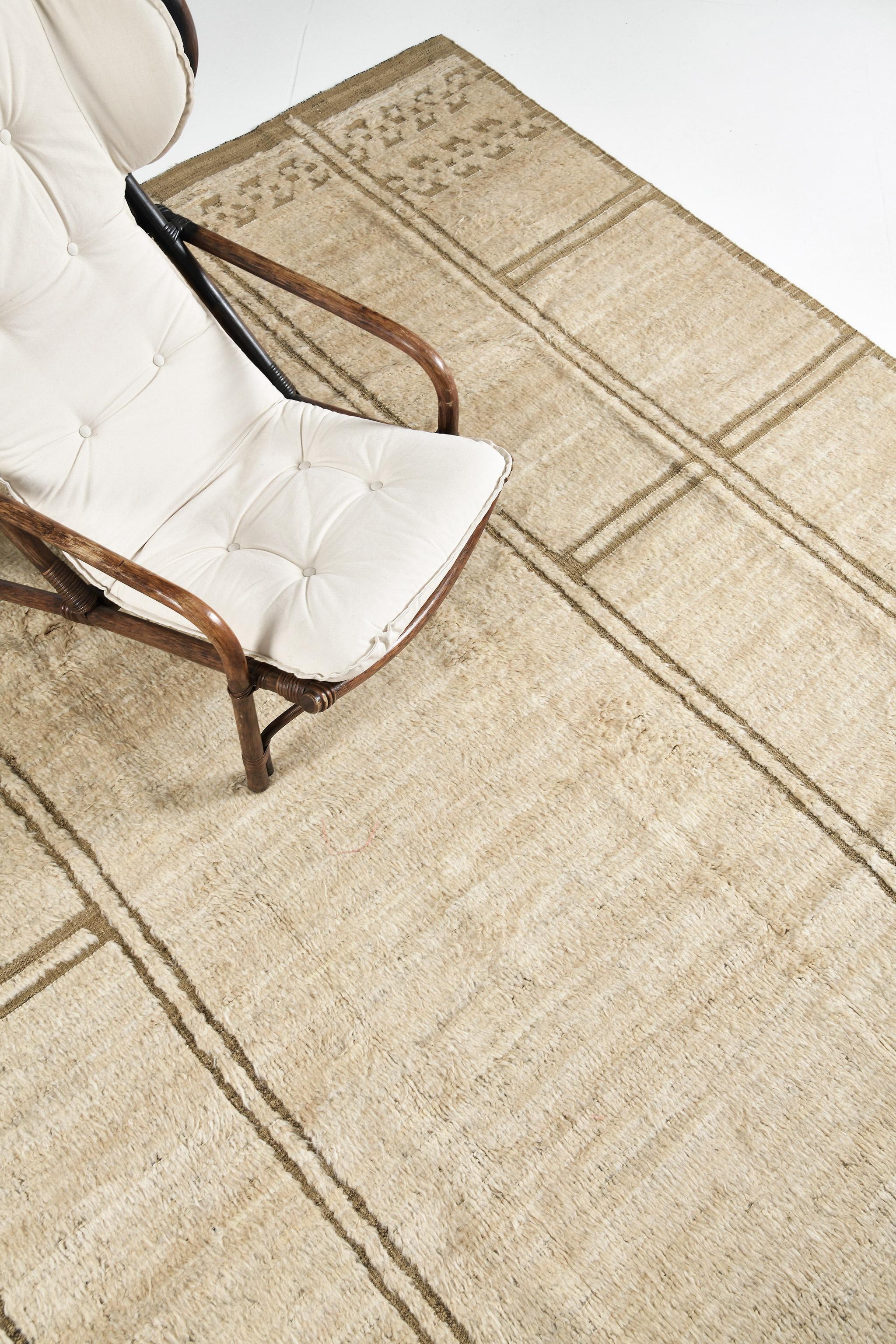 Meddur’ in Nomad Collection features an uneven grid-like rectangular pattern which adds statement and character to this wonderful rug. Rendered in beige and tan, this rug also features symbollical elements on its top and bottom of this exquisite