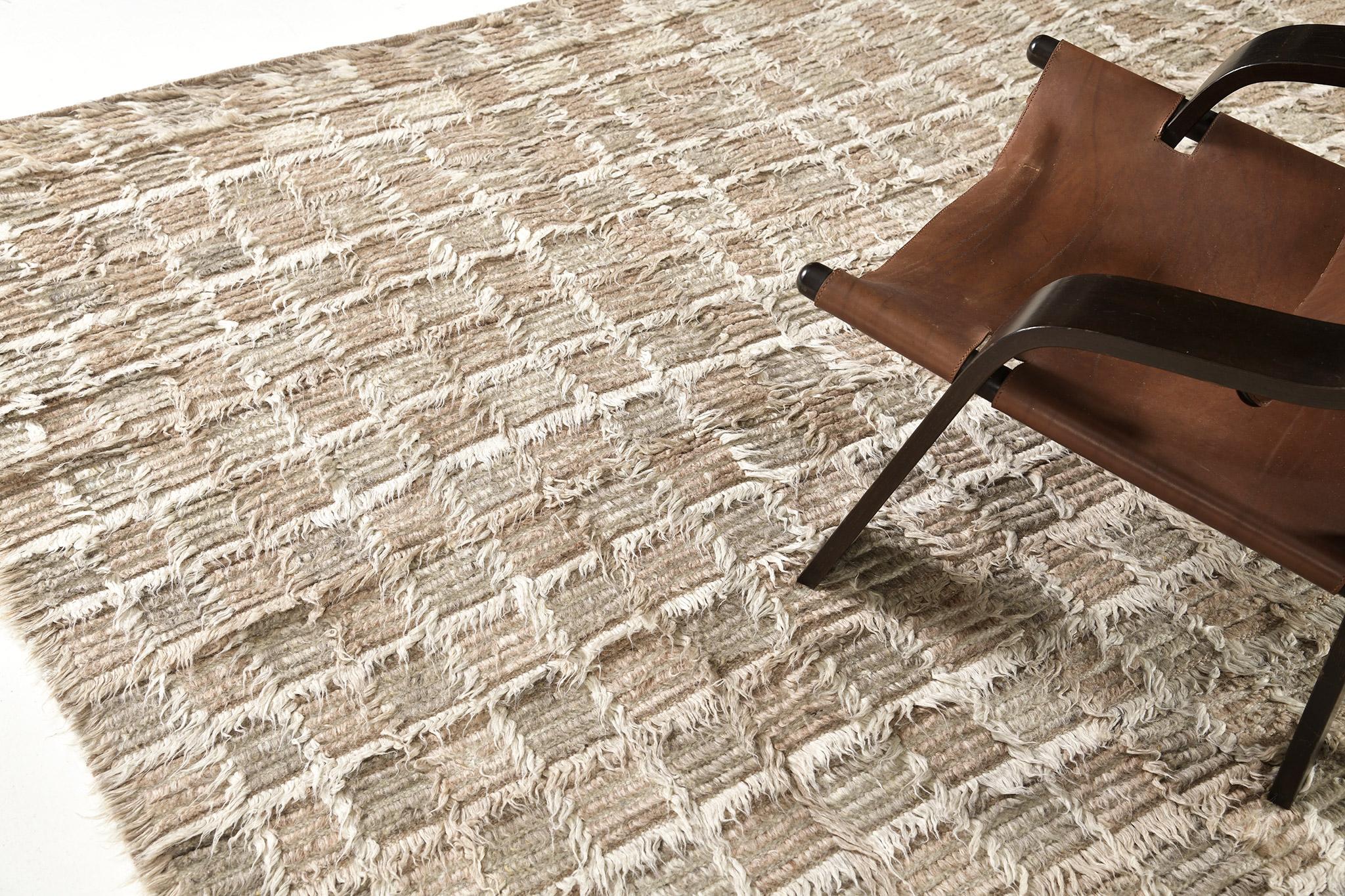 The Miha rug features a checkerboard motif interplaying shifted tonal grid lines in a multi-pile design. This piece is rendered in subtle neutrals encompassing warm clay-taupes and khaki grays. 

An extension of Mehraban’s popular Amihan design,
