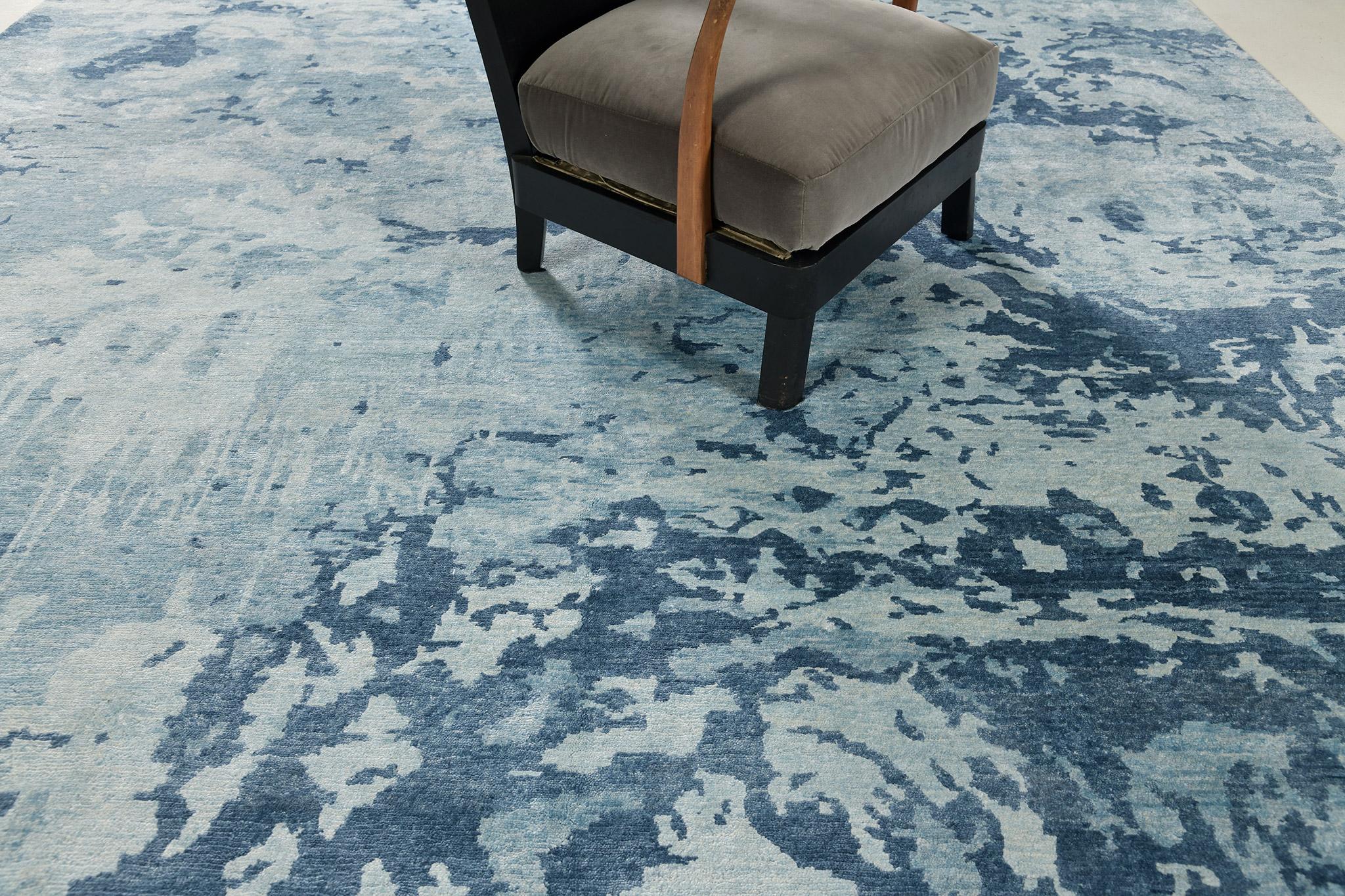 A wool pile weave that intricately weaves over the ash gray variegated ground with a profusion of blue hue elements establish. This exceptional modern design from the Elan collection is the epitome of elegance and refinement. A dashing