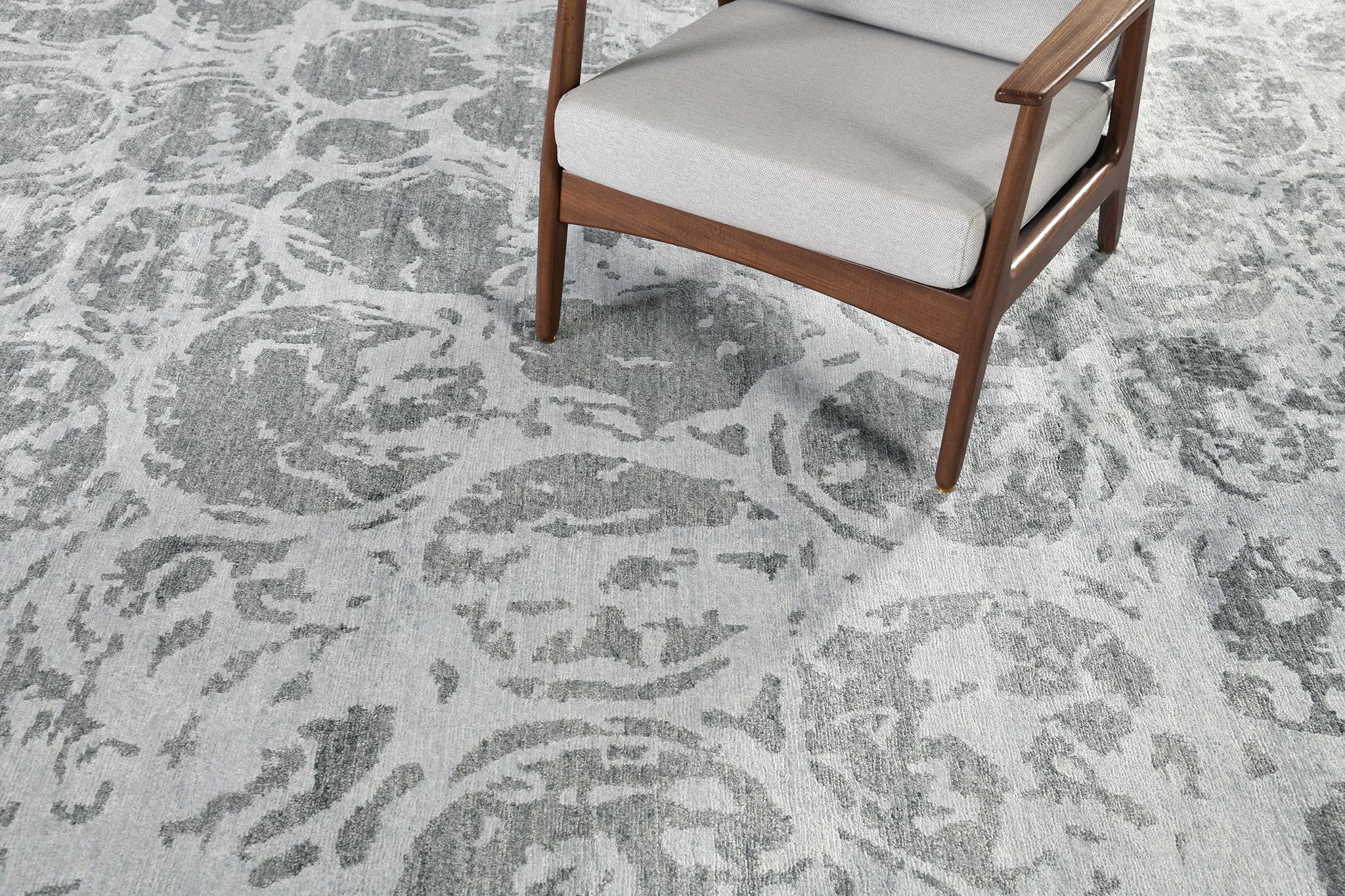 This outstanding modern design from the Elan collection is the quintessence of elegance and refinement. A wool pile weave that intricately weaves over the ash gray variegated ground with a profusion of blue and ash elements set. A fashionable