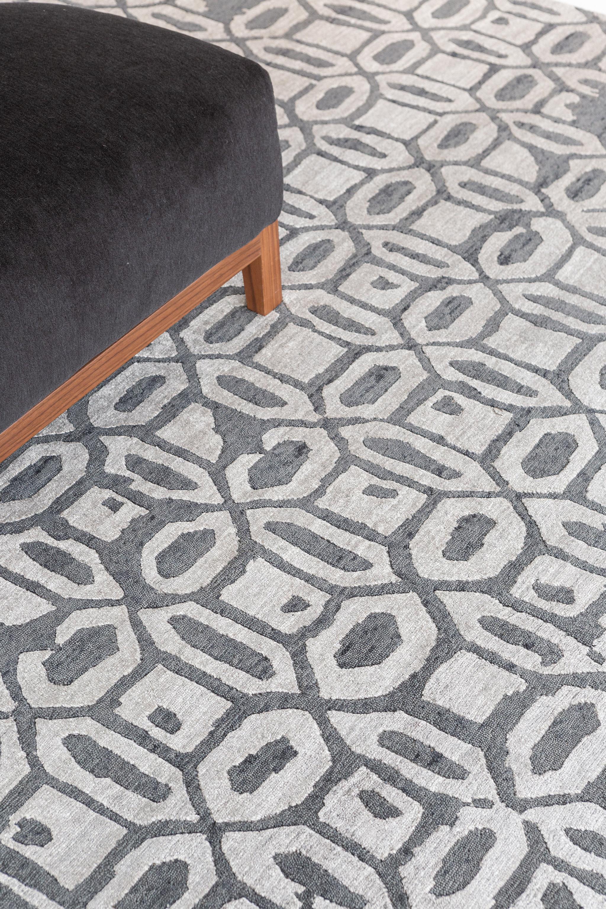 This classic Rallegra Modern Design Bamboo Silk rug features a geometric pattern, with its playful combination of charcoal and gray powerful colors. It is just as trendy and refined at the same time, perfect for any connoisseur of a fine