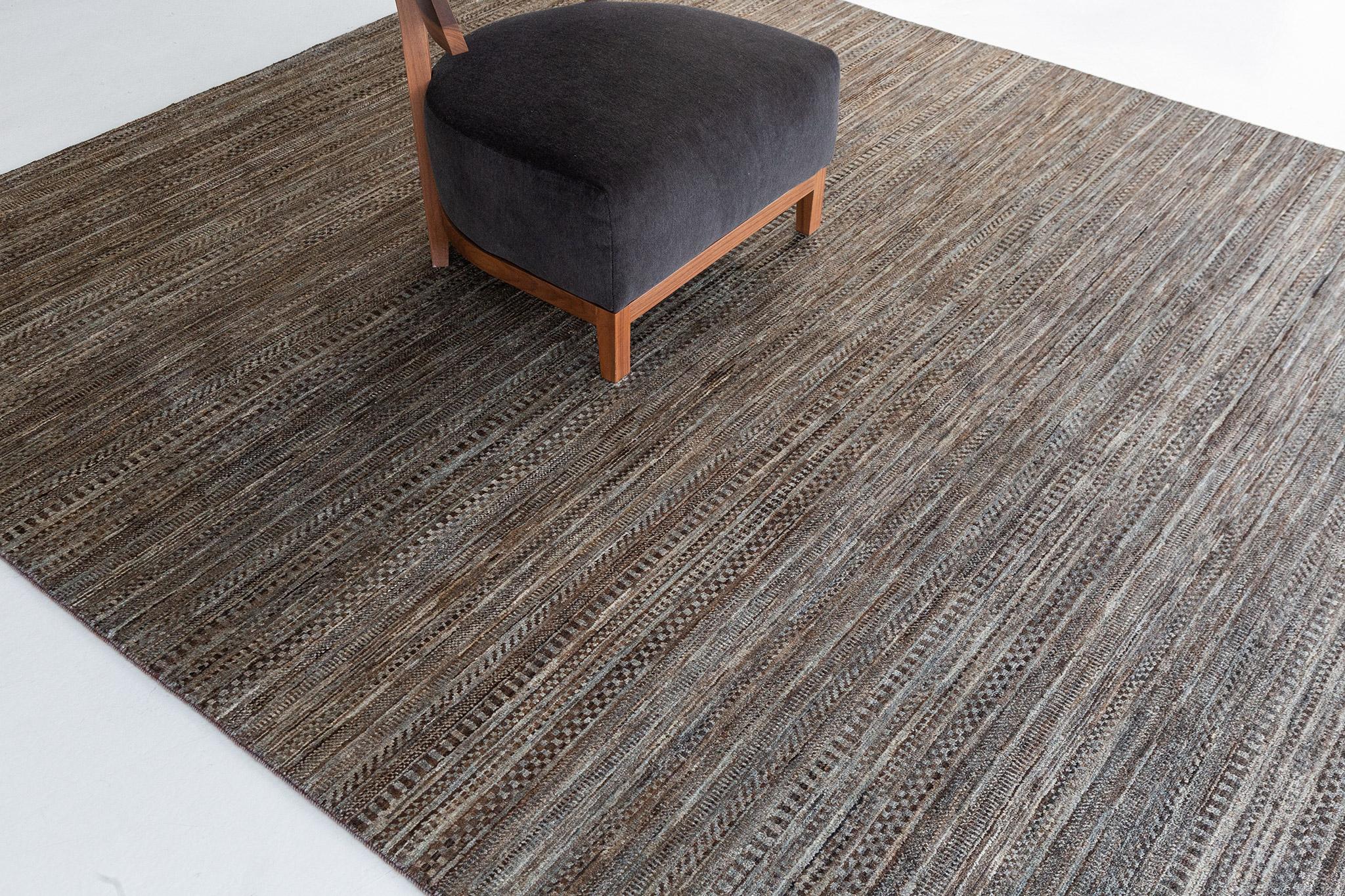Vintaj is luxurious wool with horizontal strokes in deep gradations of charcoal, ivory, and cream. Its handwoven wool features a series of free-spirited rugs that feels innately soft underfoot and is enhanced by extraordinary, valiant designs worthy