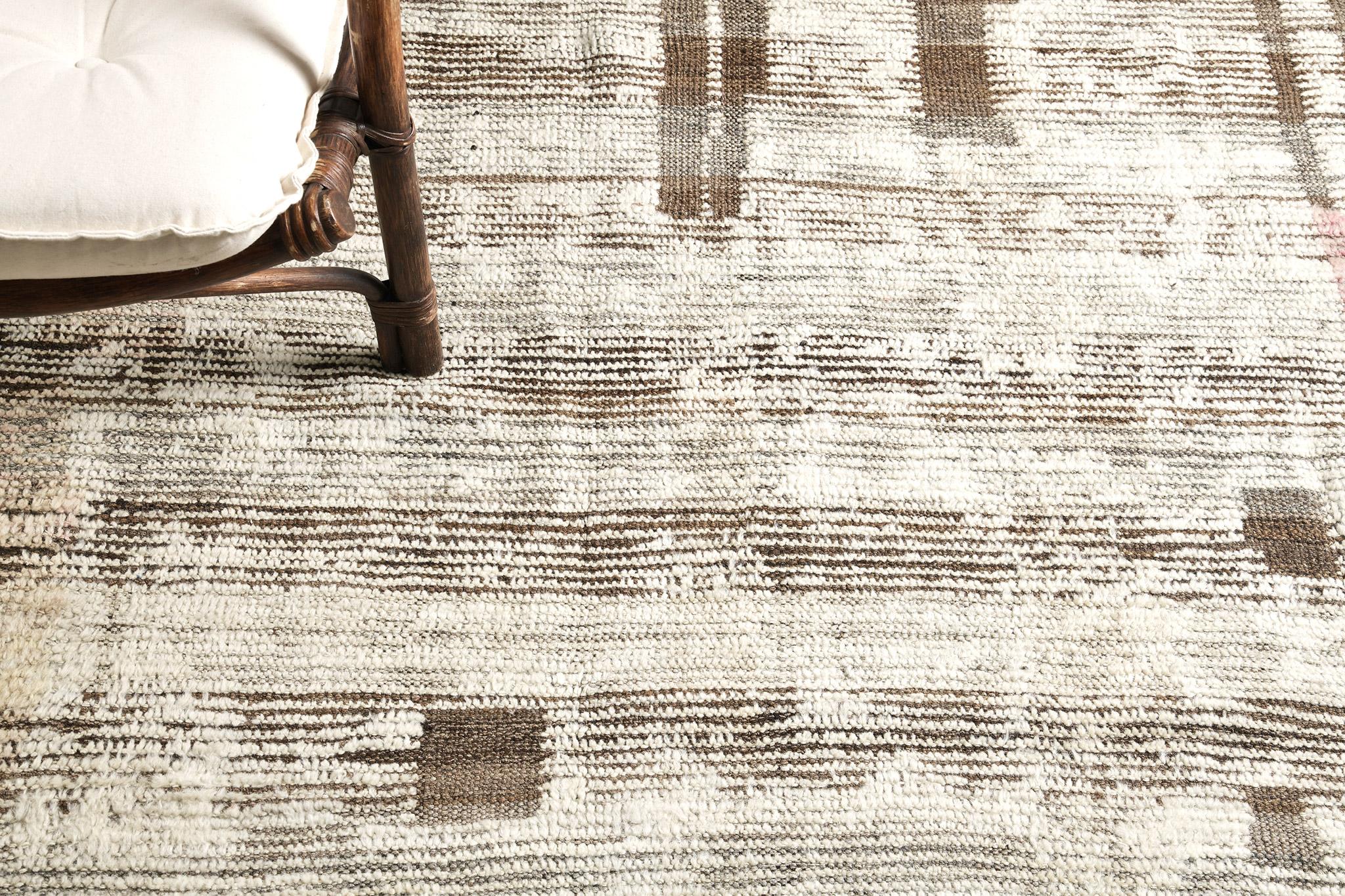 Nakhla' is a natural earth toned rug and a modern interpretation of the Moroccan world. This rugs irregular ecru, coffee and charcoal strokes resembles the fibers of nature and their ability to be used for crafts such as cords and basketry. Designed