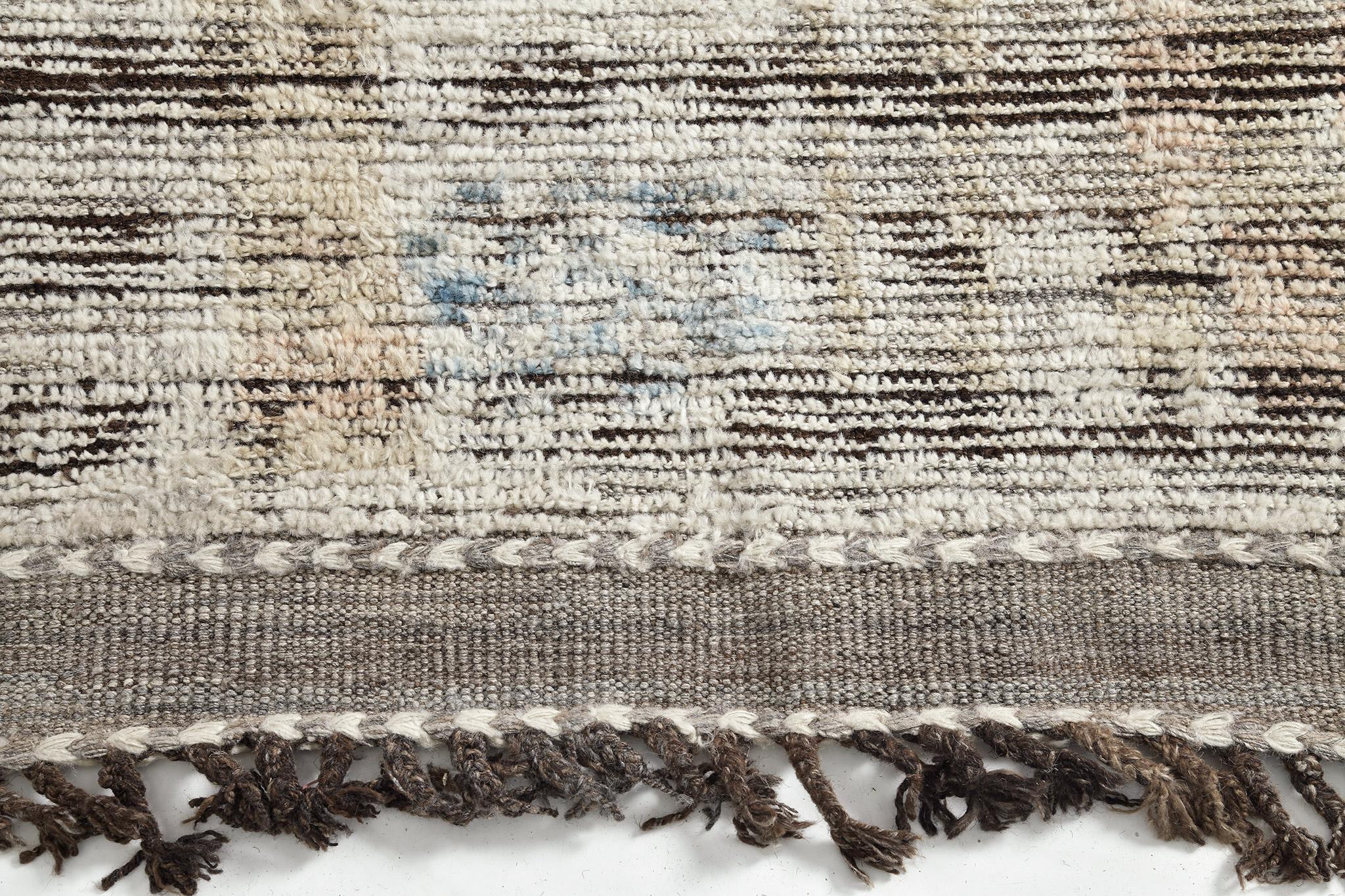 Nakhla' is a natural earth toned rug and a modern interpretation of the Moroccan world. This rugs irregular sand, khaki, cerulean blue, and salt and pepper strokes resembles the fibers of nature and their ability to be used for crafts such as cords